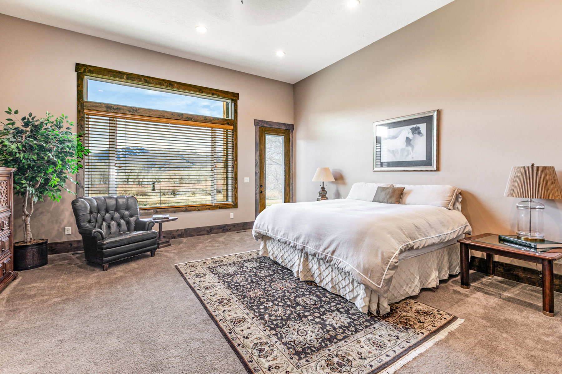 Room featuring a large picture window with mountain scenery, recessed ceiling lighting, and a wood-framed glass door