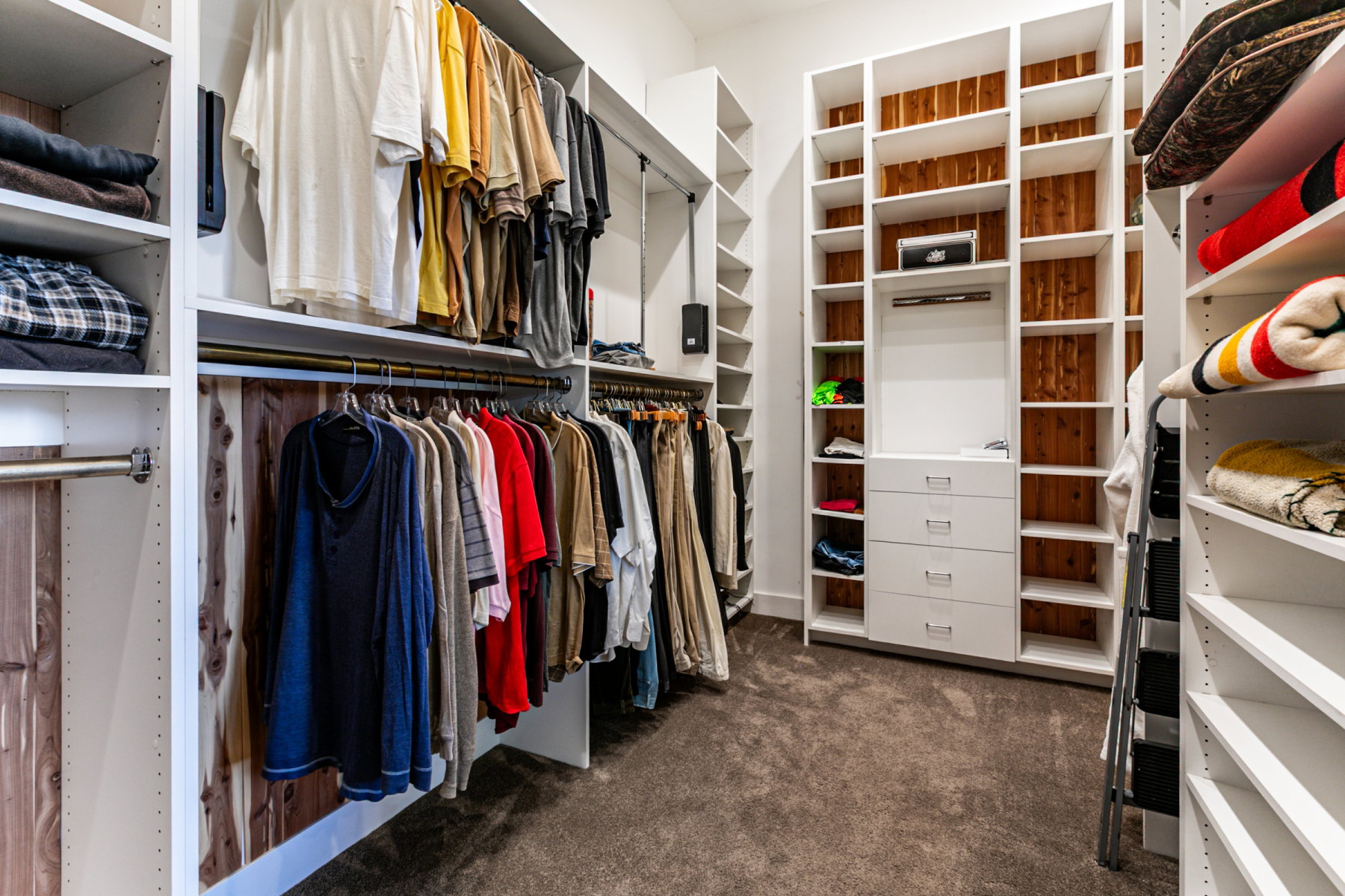 Custom closet system featuring extensive shelving, integrated drawers, hanging rods, and cedar backing