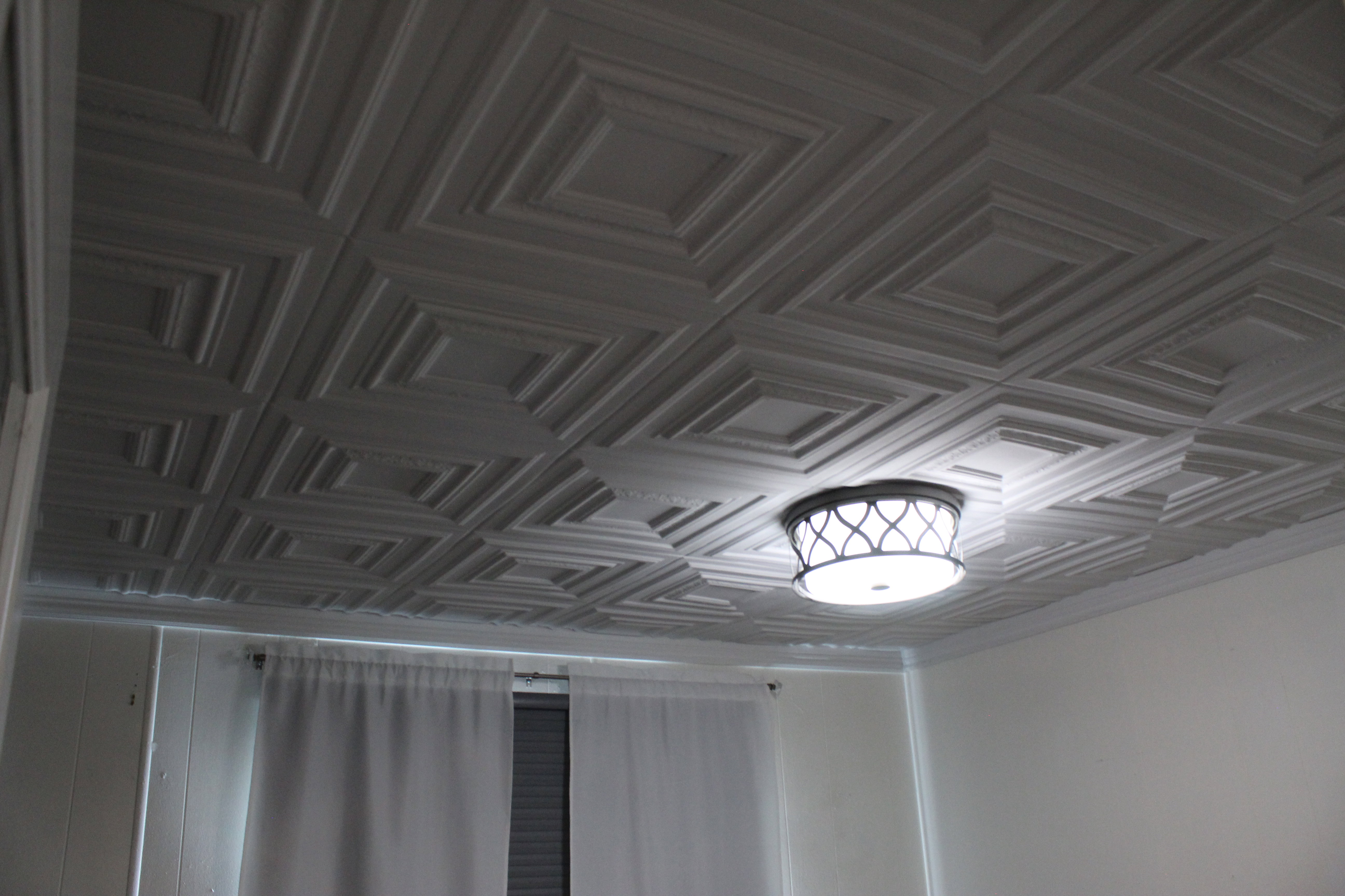 First Bedroom. Coffered ceiling with a geometric pattern and a decorative flush-mount light fixture.  first bedroom