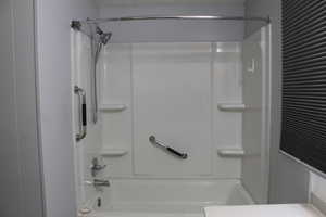 Primary bathroom White acrylic tub and shower combination with chrome fixtures