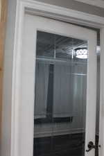 First bedroom. White French door with glass panels and a dark-finish door handle. First bedroom door