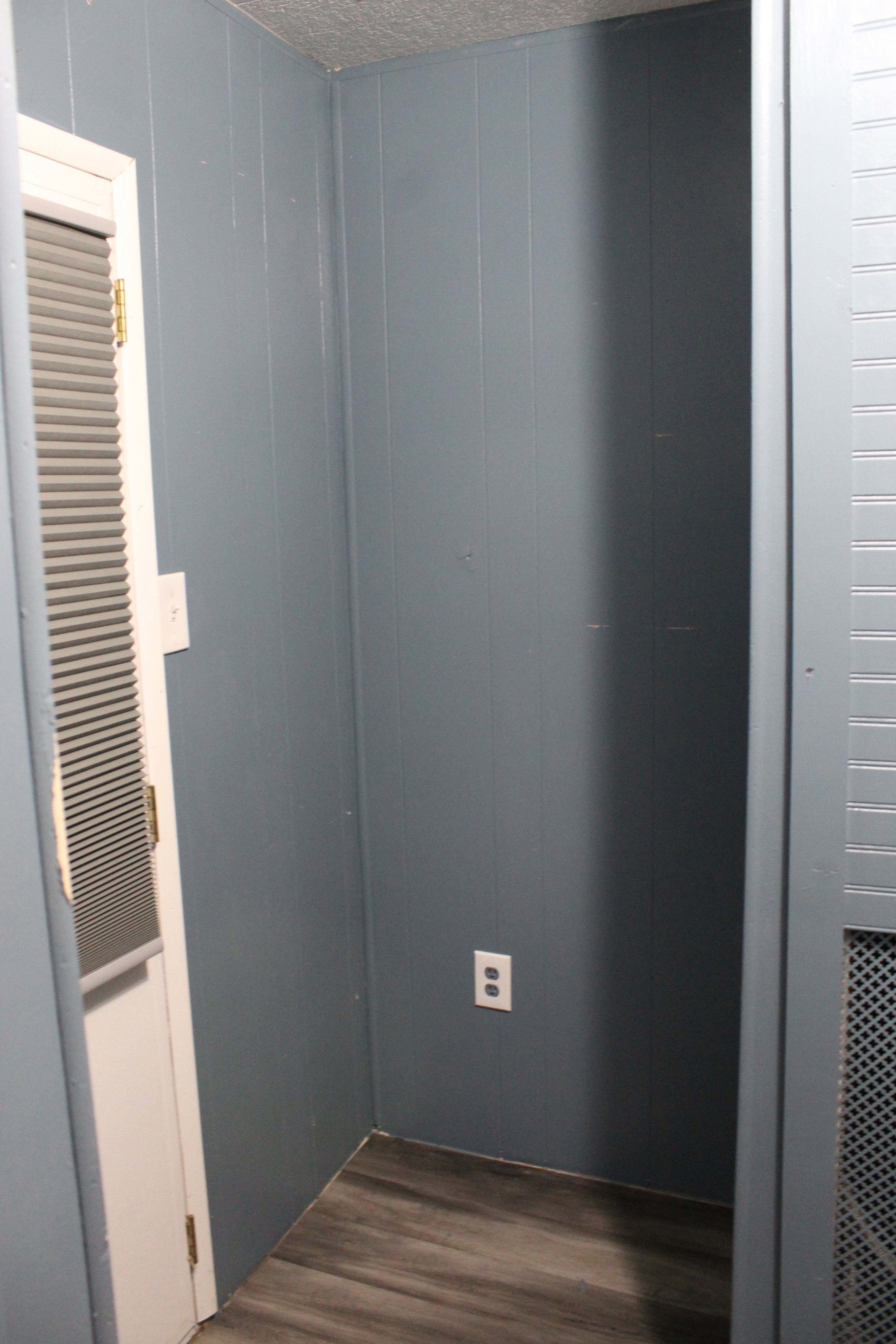 Recessed wall space featuring wood-finish flooring and a power outlet