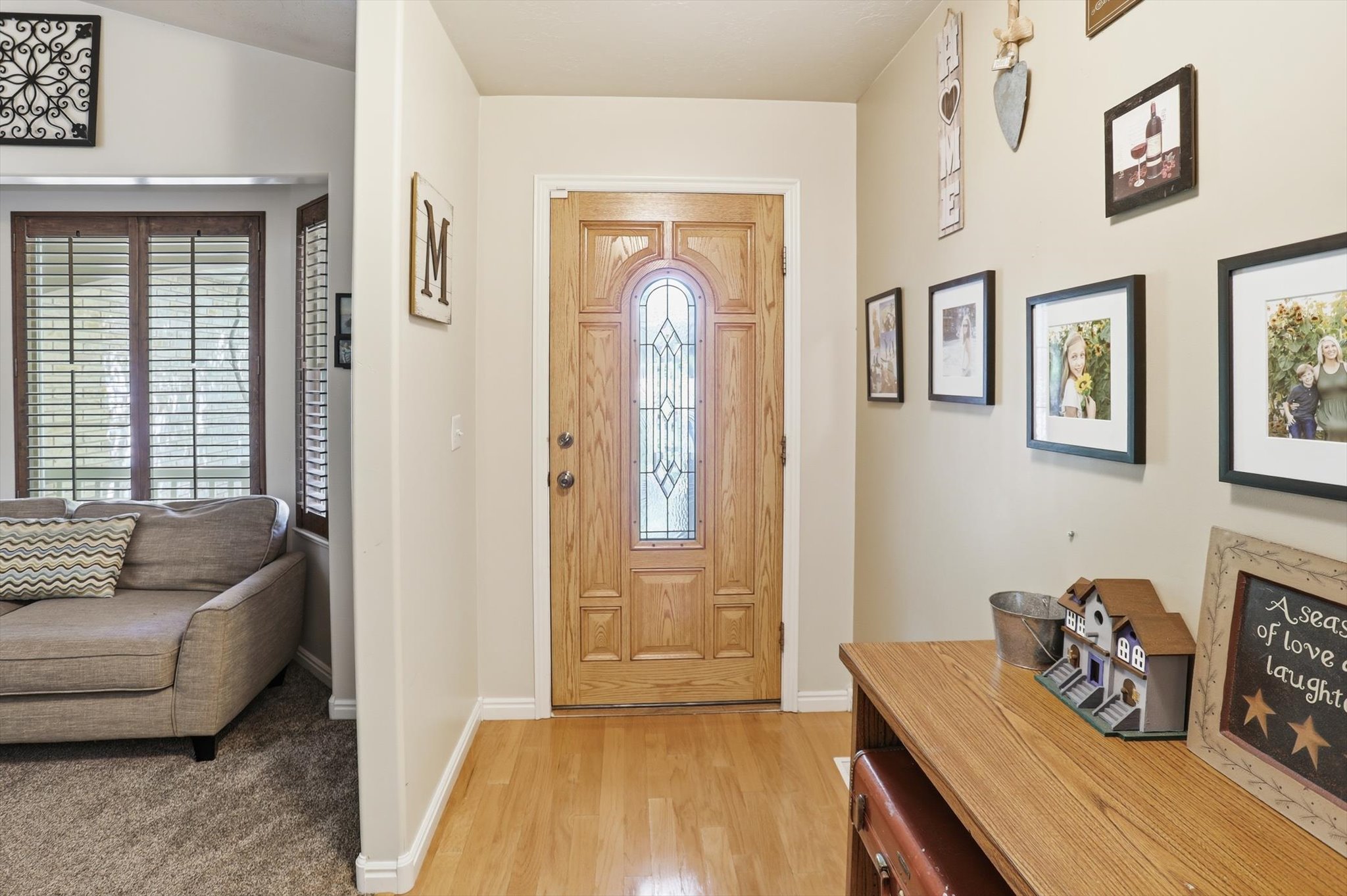 Entryway featuring a wood-panel door with leaded glass insert, light wood-finish flooring, and neutral wall tones
