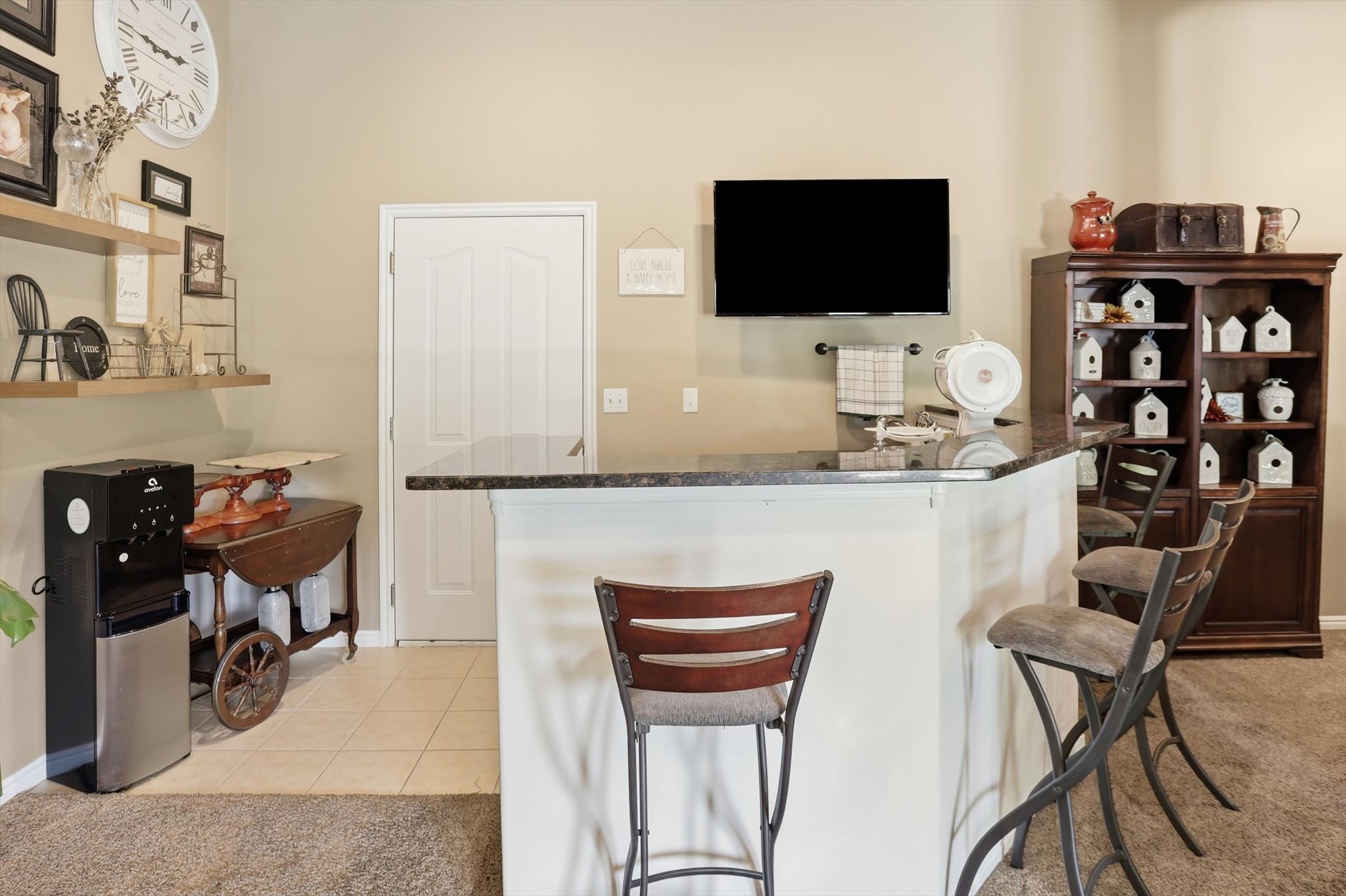 Kitchen island with a dark countertop and seating for three