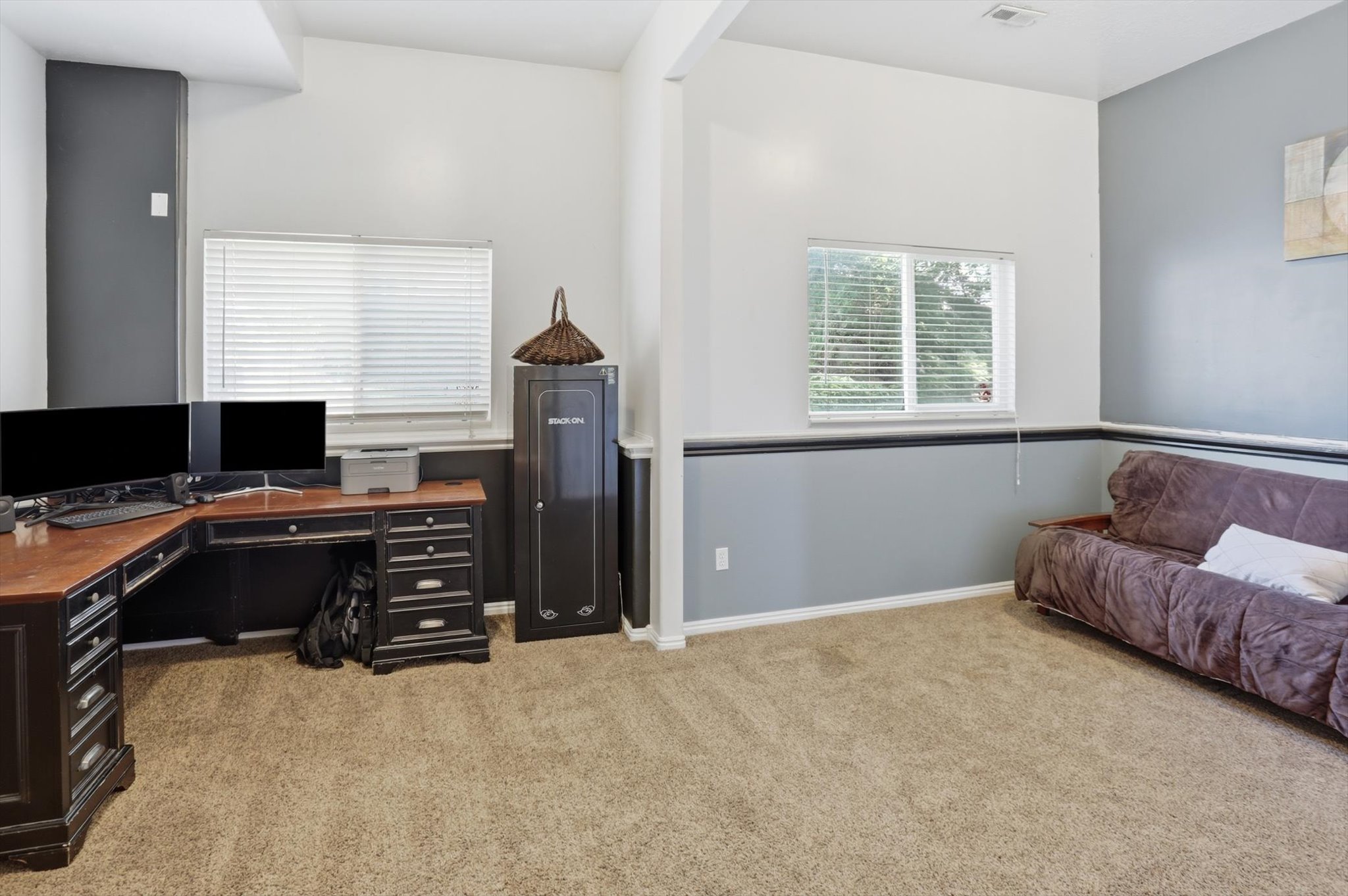 Versatile space featuring light-colored walls with a contrasting chair rail and dark accent walls