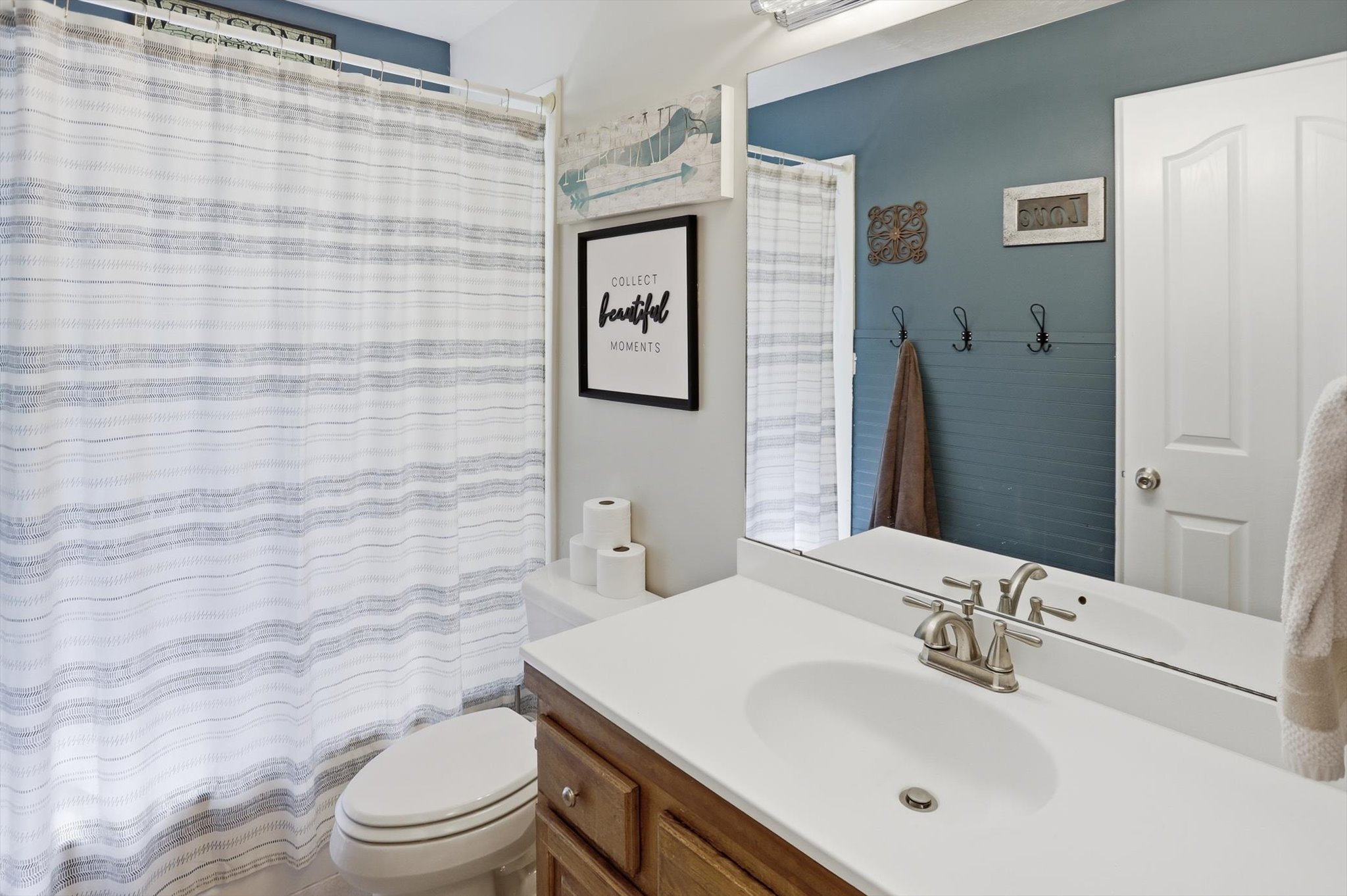 Bathroom vanity with an integrated white sink, brushed nickel faucet, and wood-finish cabinetry