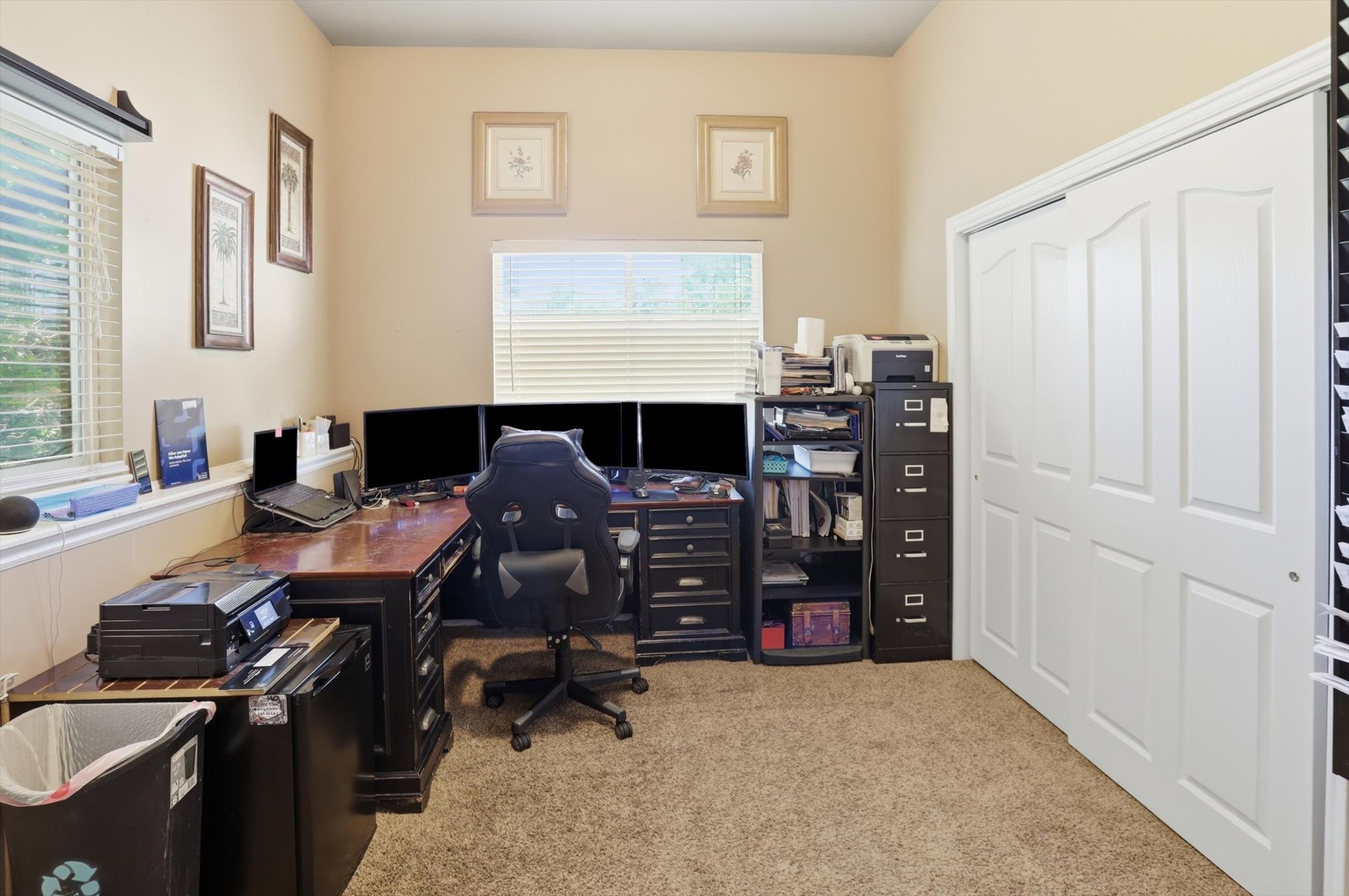 Carpeted room with vaulted ceilings and two windows featuring horizontal blinds