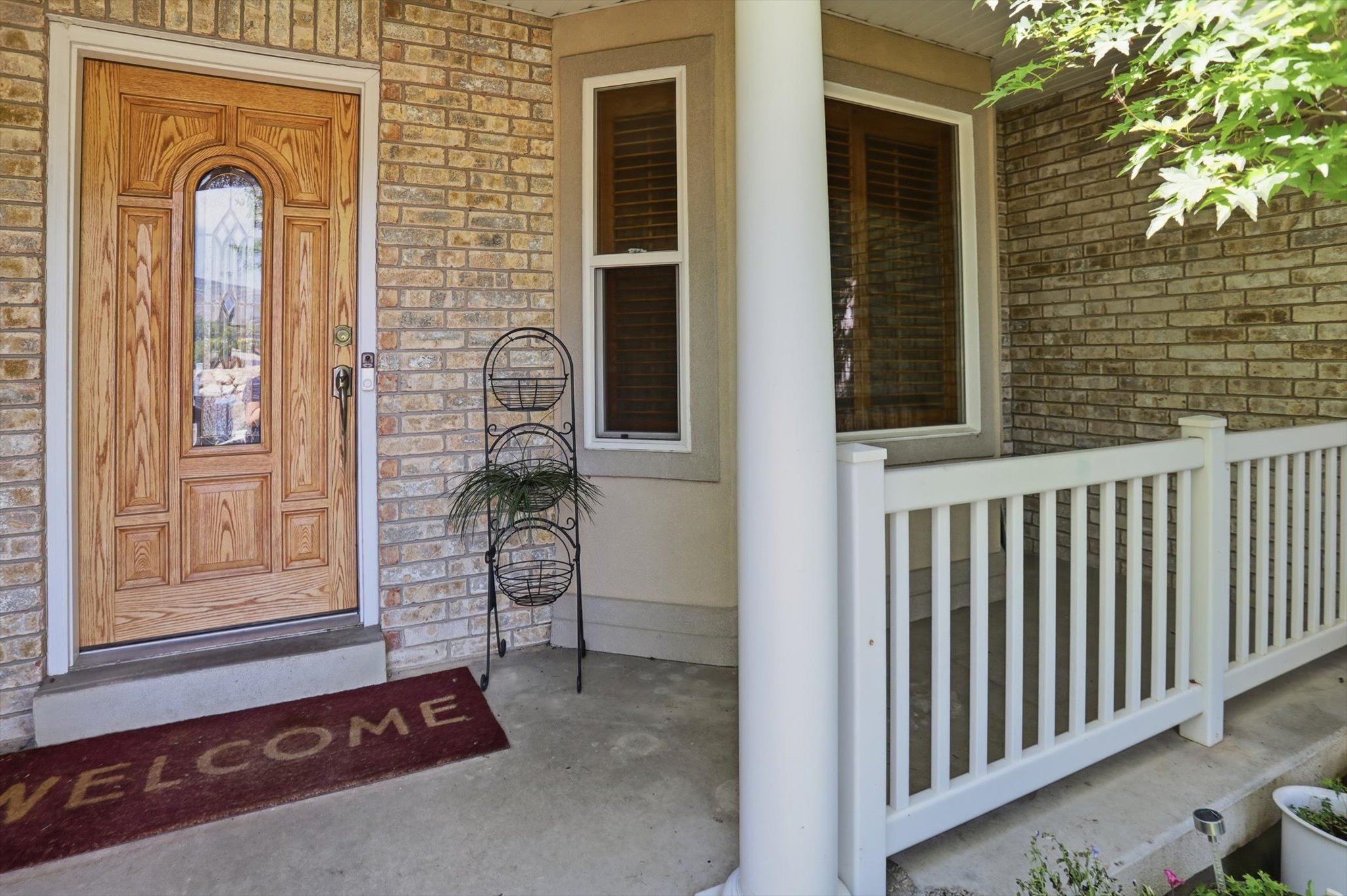 Inviting front entryway featuring a light wood-finish door with decorative glass inlay
