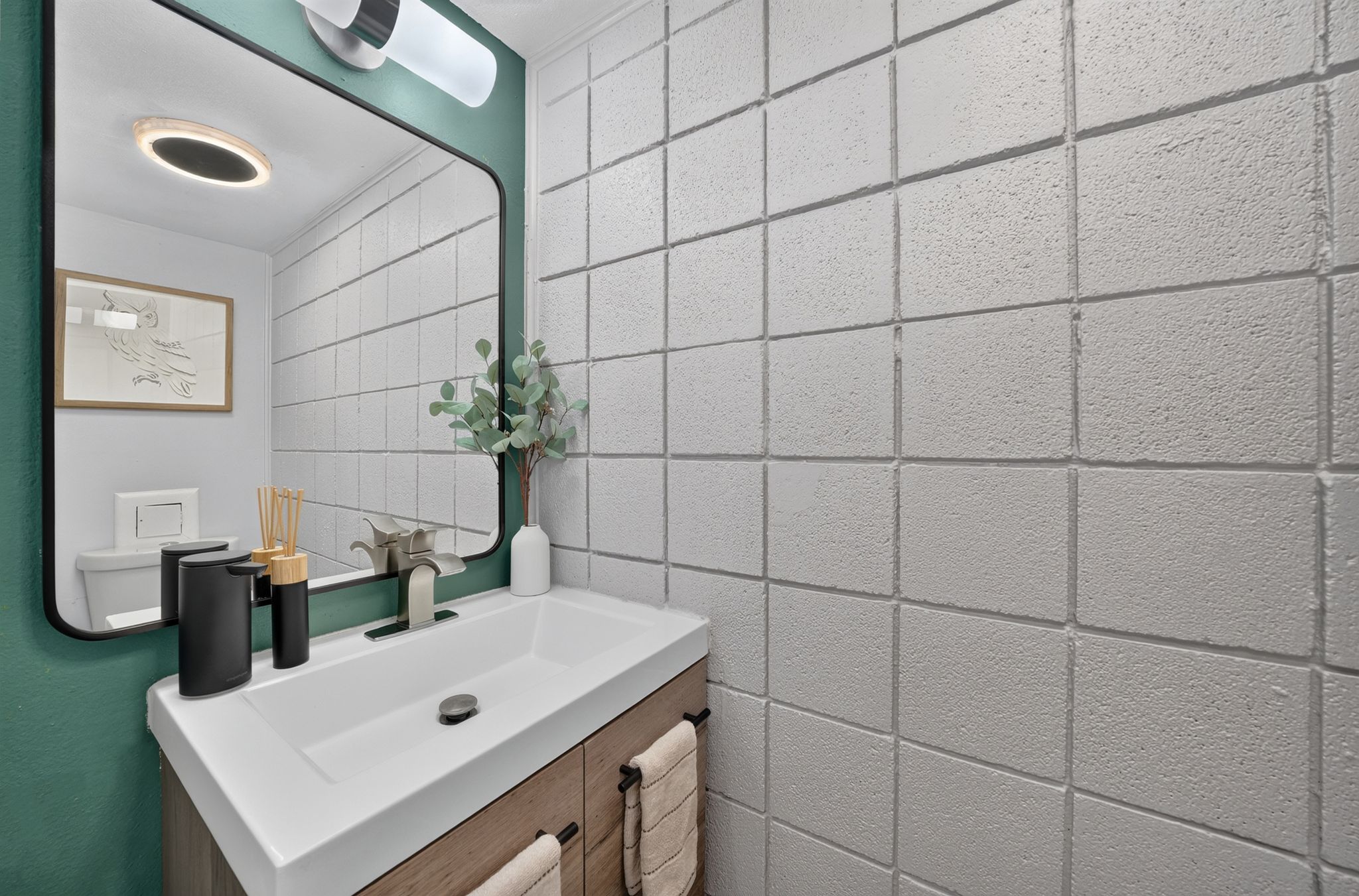 Contemporary bathroom featuring a floating wood-finish vanity with an integrated rectangular sink