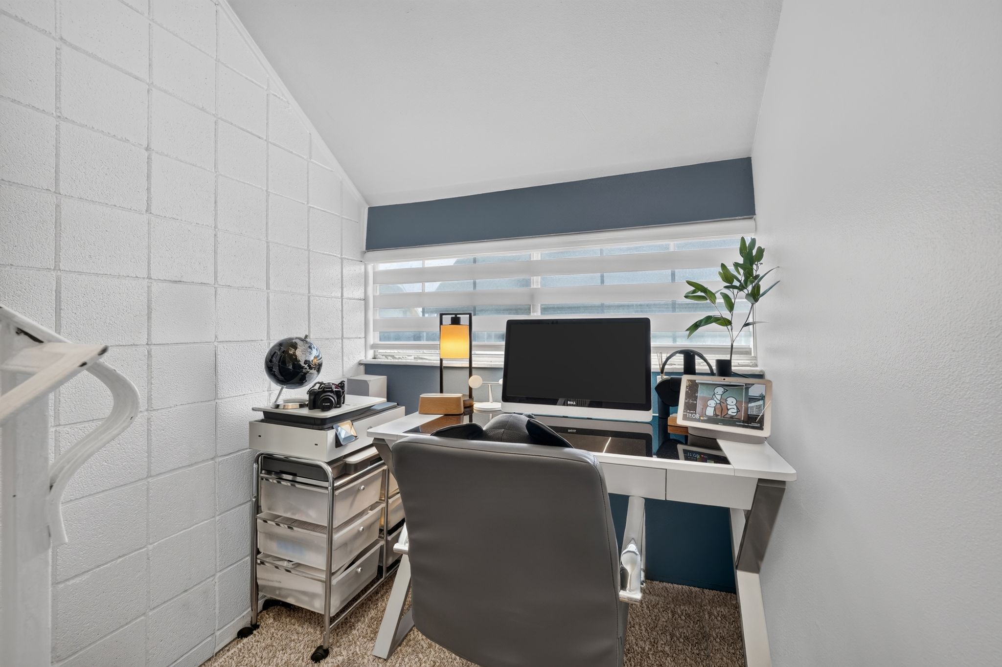 Dedicated workspace featuring an angled ceiling and textured wall panels