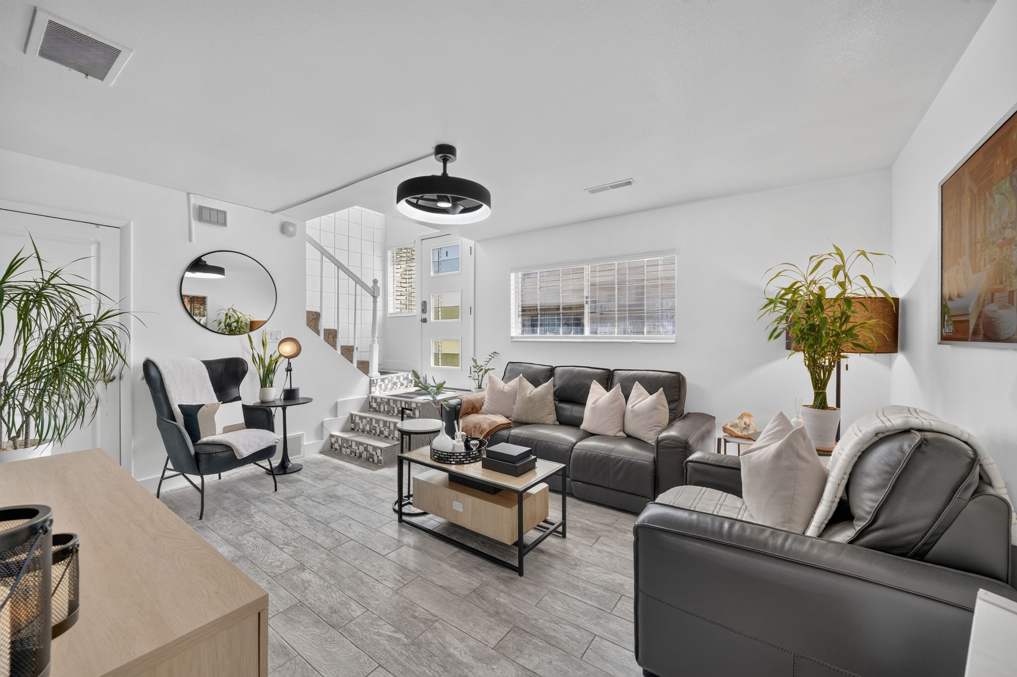 Living area featuring wood-finish tile flooring and crisp white walls