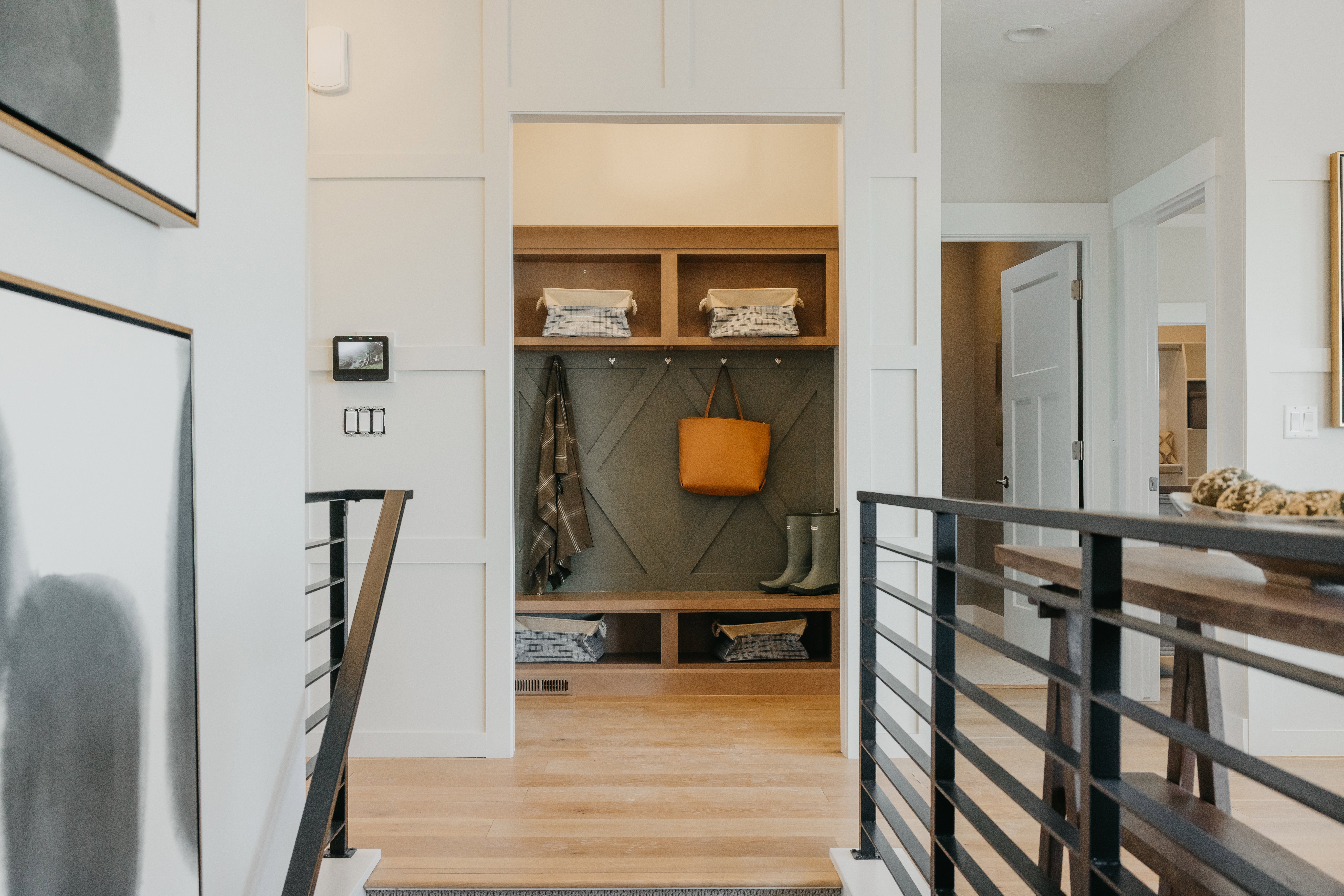 Built-in mudroom with open shelving, integrated bench seating, and decorative paneling