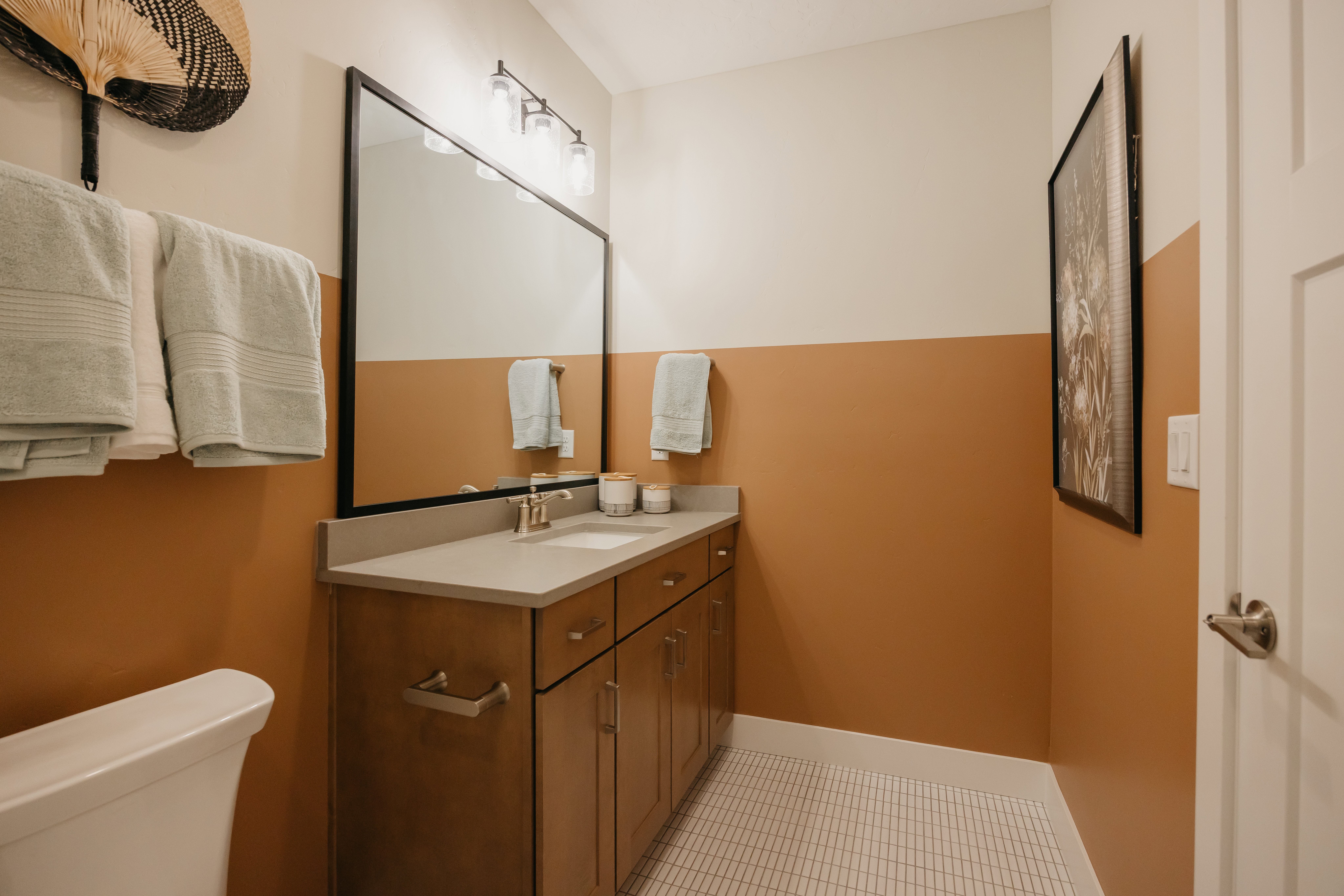 Bathroom featuring a wood-finish vanity with ample storage, a light-toned countertop, and a rectangular undermount sink