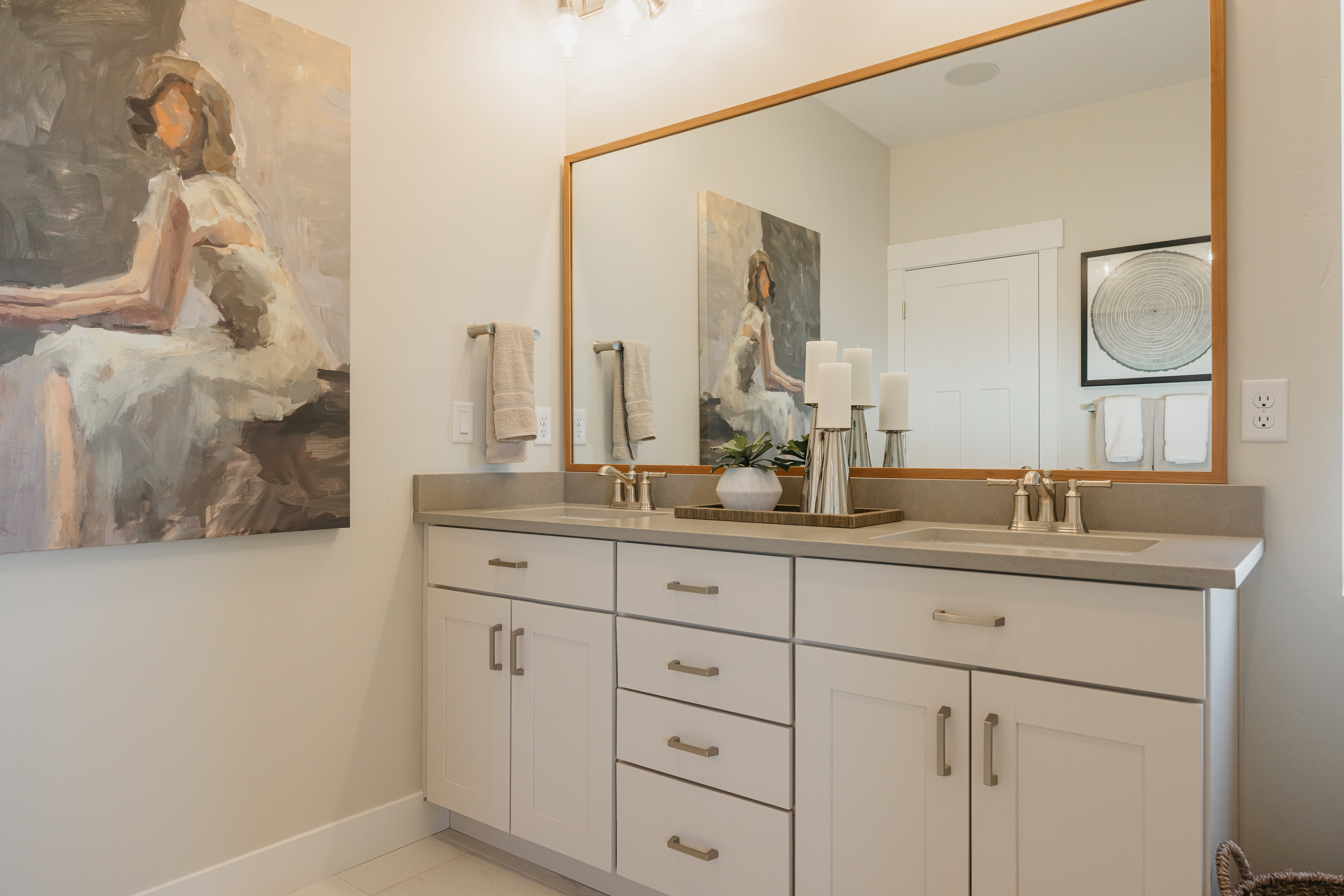 Double vanity featuring light-toned cabinetry and a stone-finish countertop