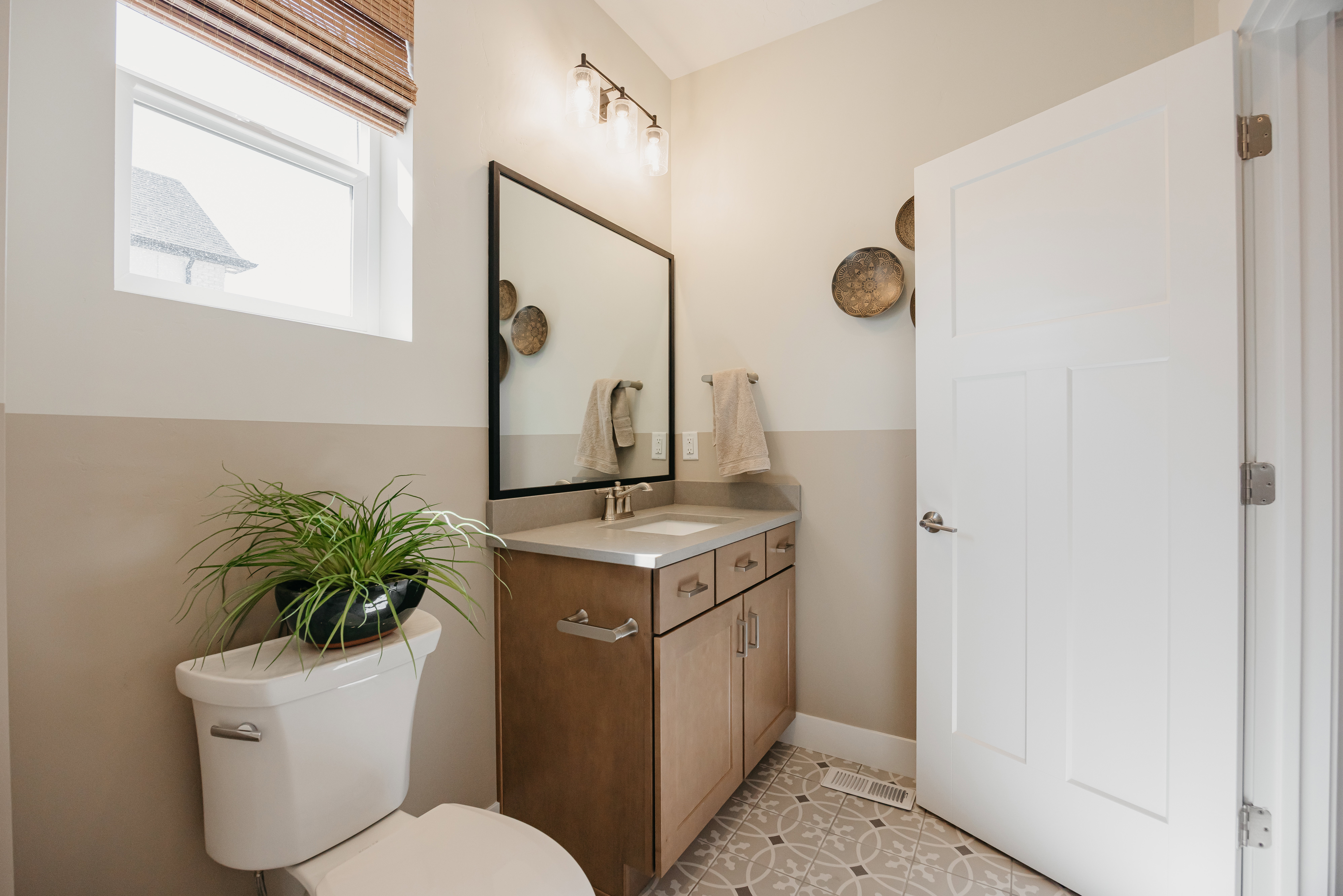 Bathroom featuring a wood-finish vanity with a light countertop, a rectangular mirror, and a three-light fixture