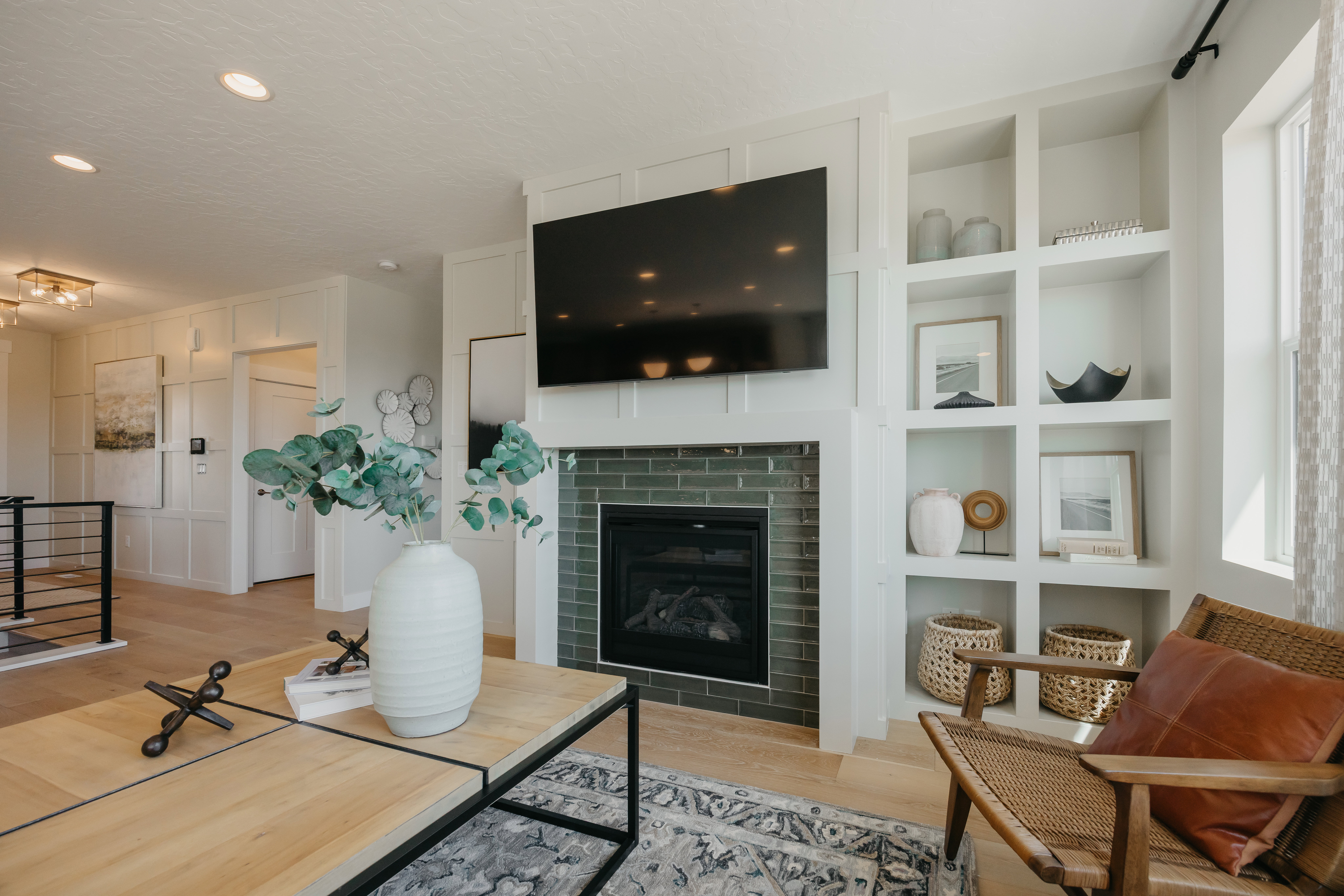 Contemporary fireplace featuring dark green subway tile surround and integrated built-in shelving