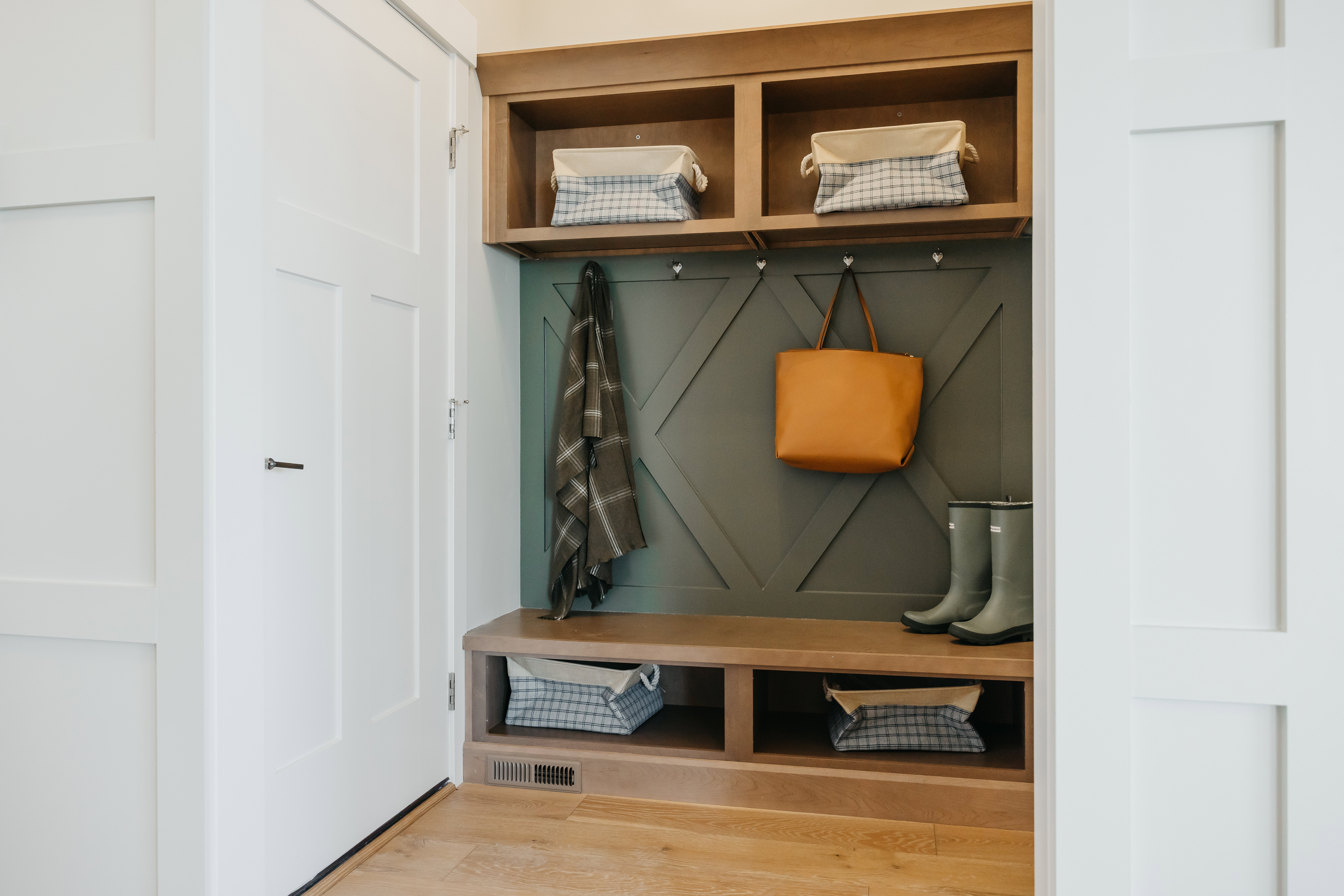 Built-in mudroom organization featuring a bench, upper cubbies, and lower storage compartments