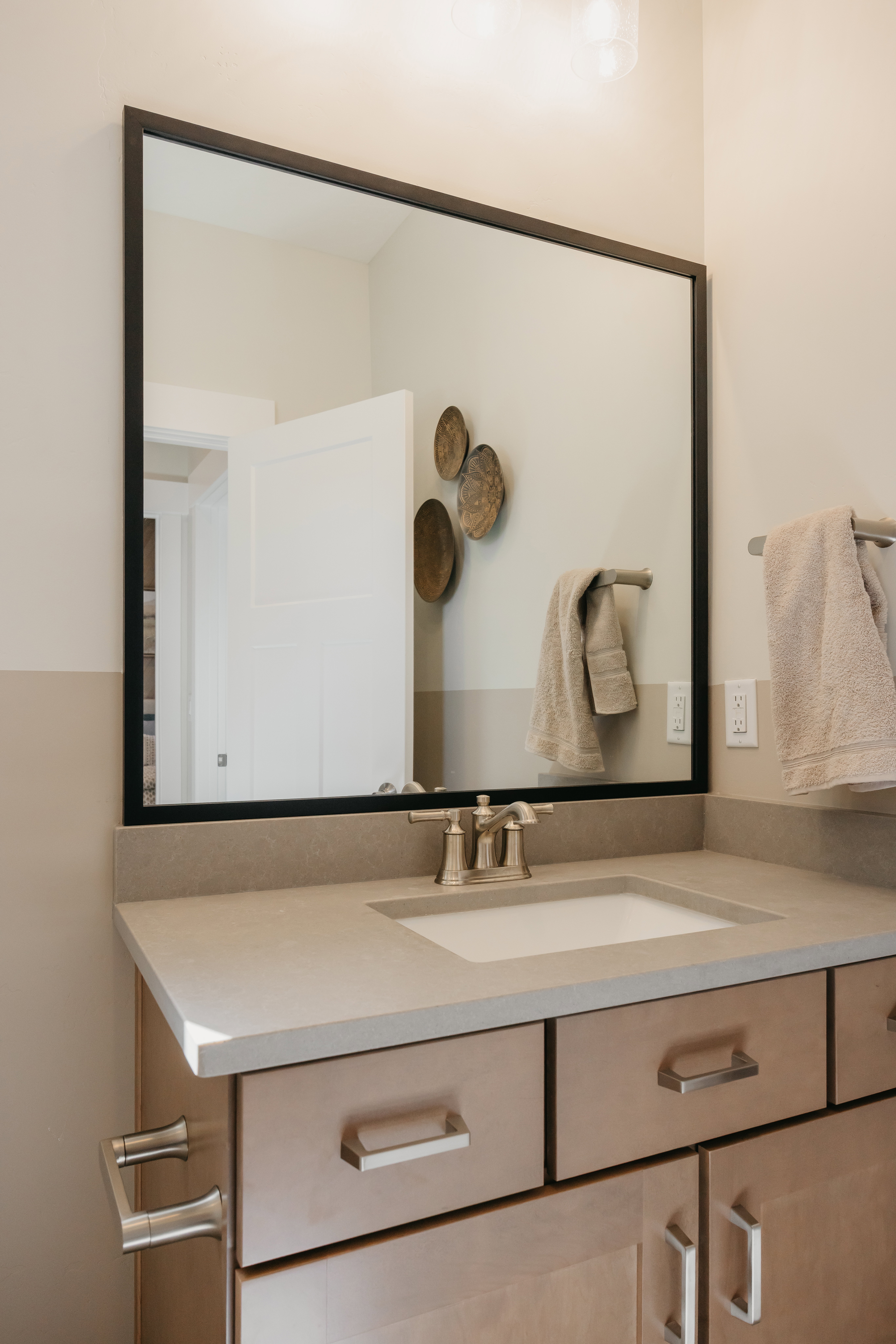 Bathroom vanity featuring a light-toned countertop, an undermount sink, and a brushed nickel faucet