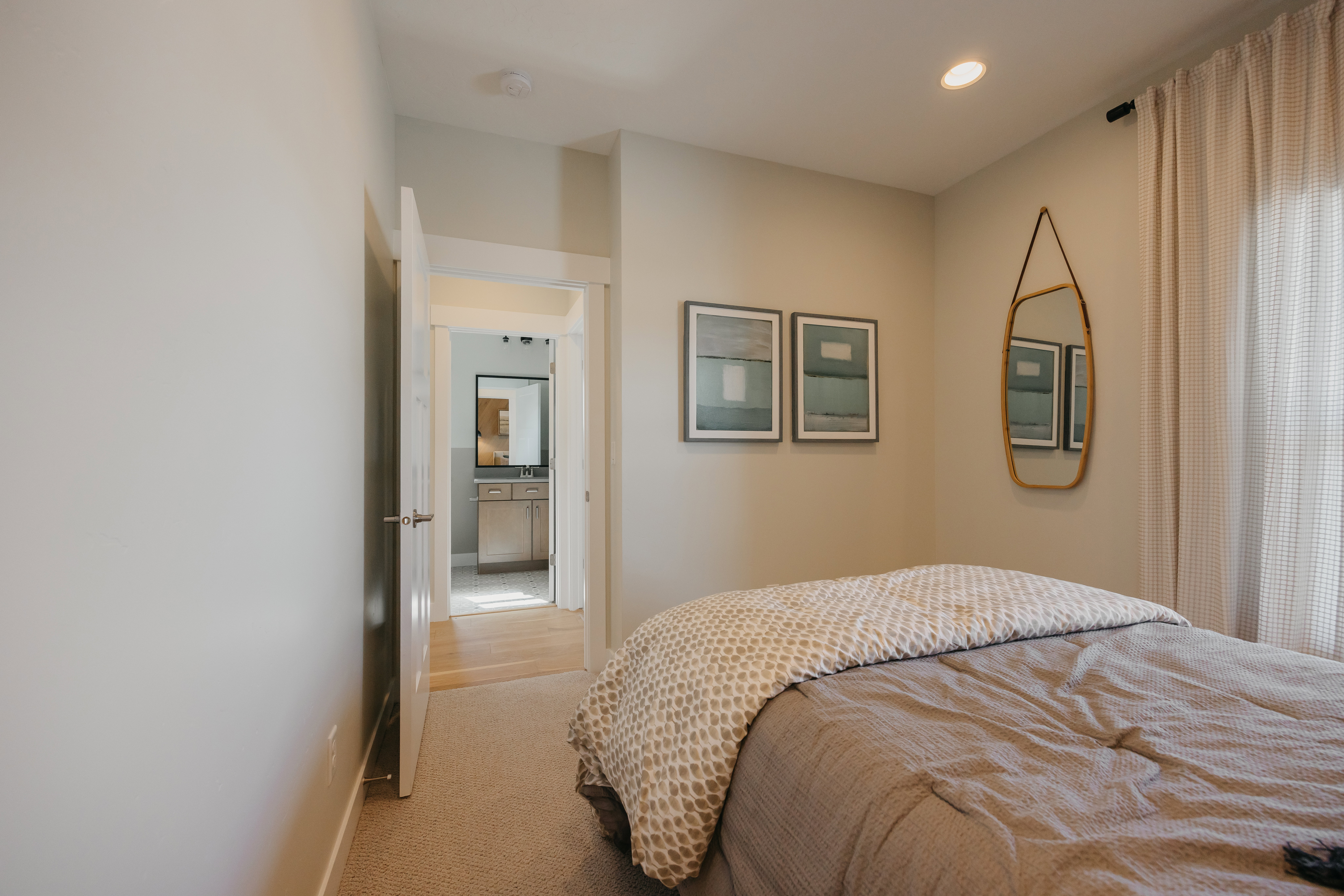 Carpeted room with recessed lighting and a doorway opening to a hardwood-finish hallway