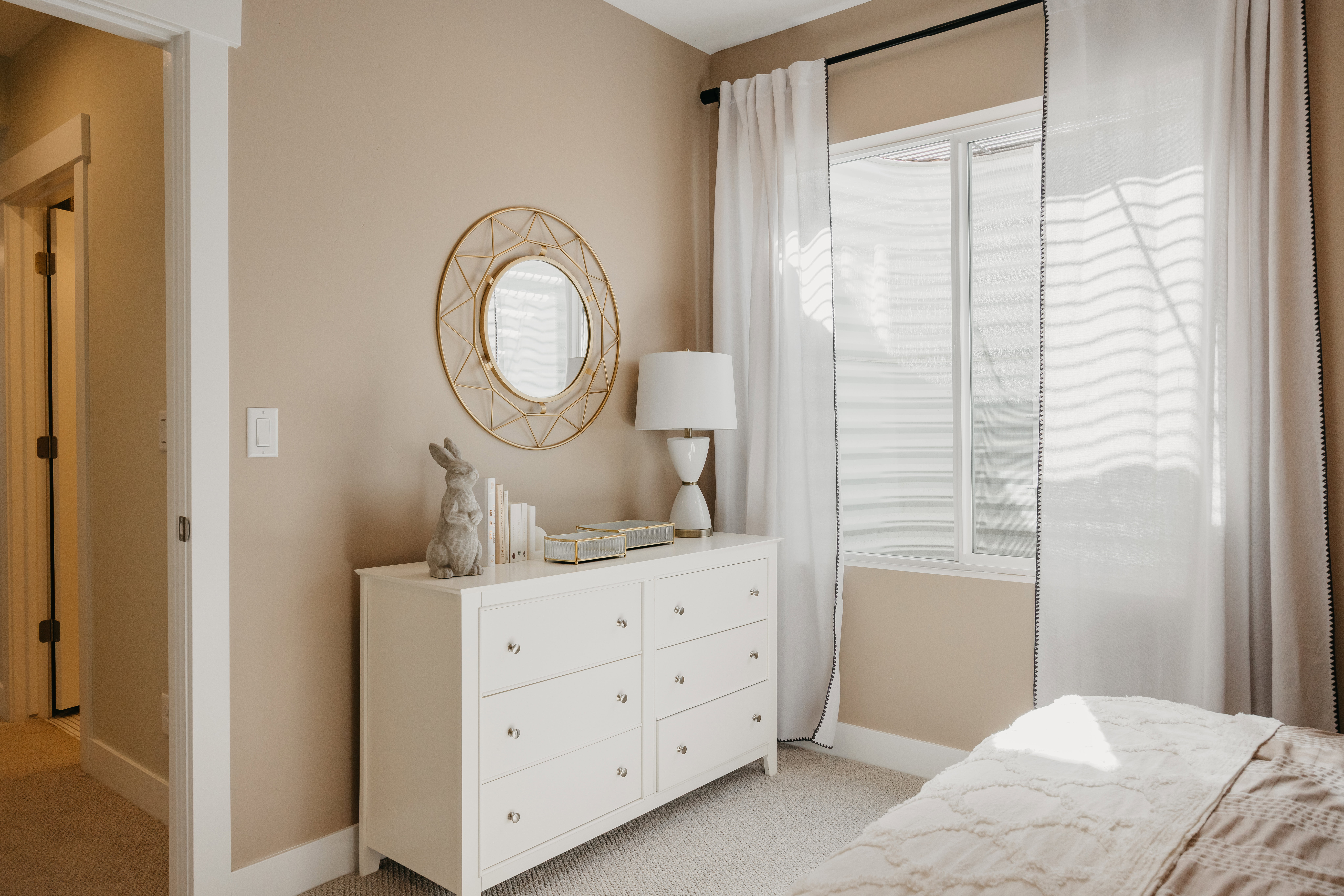 Bedroom featuring a window with white blinds, neutral wall paint, and white trim