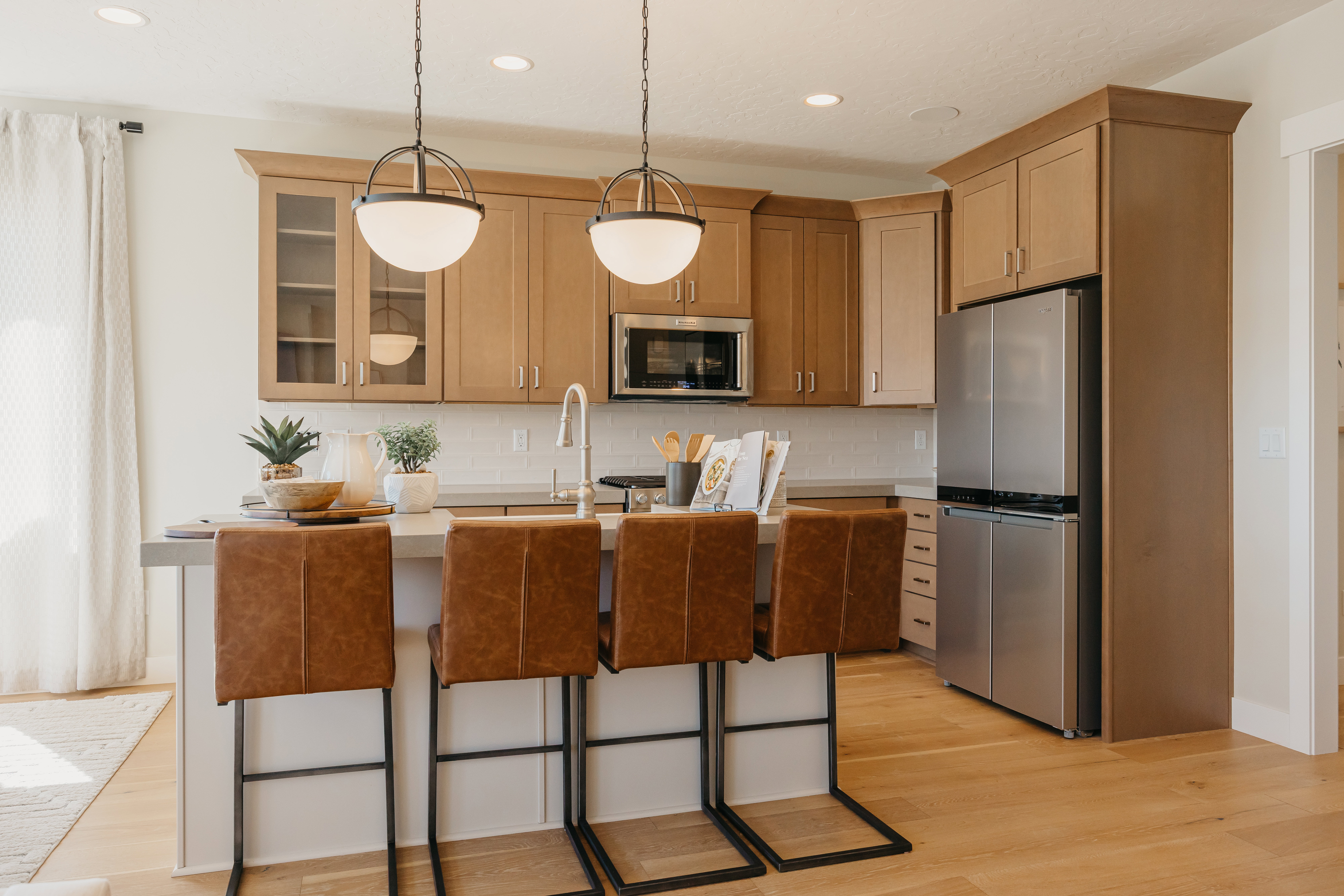 Contemporary kitchen featuring wood-finish flooring and a white subway tile backsplash