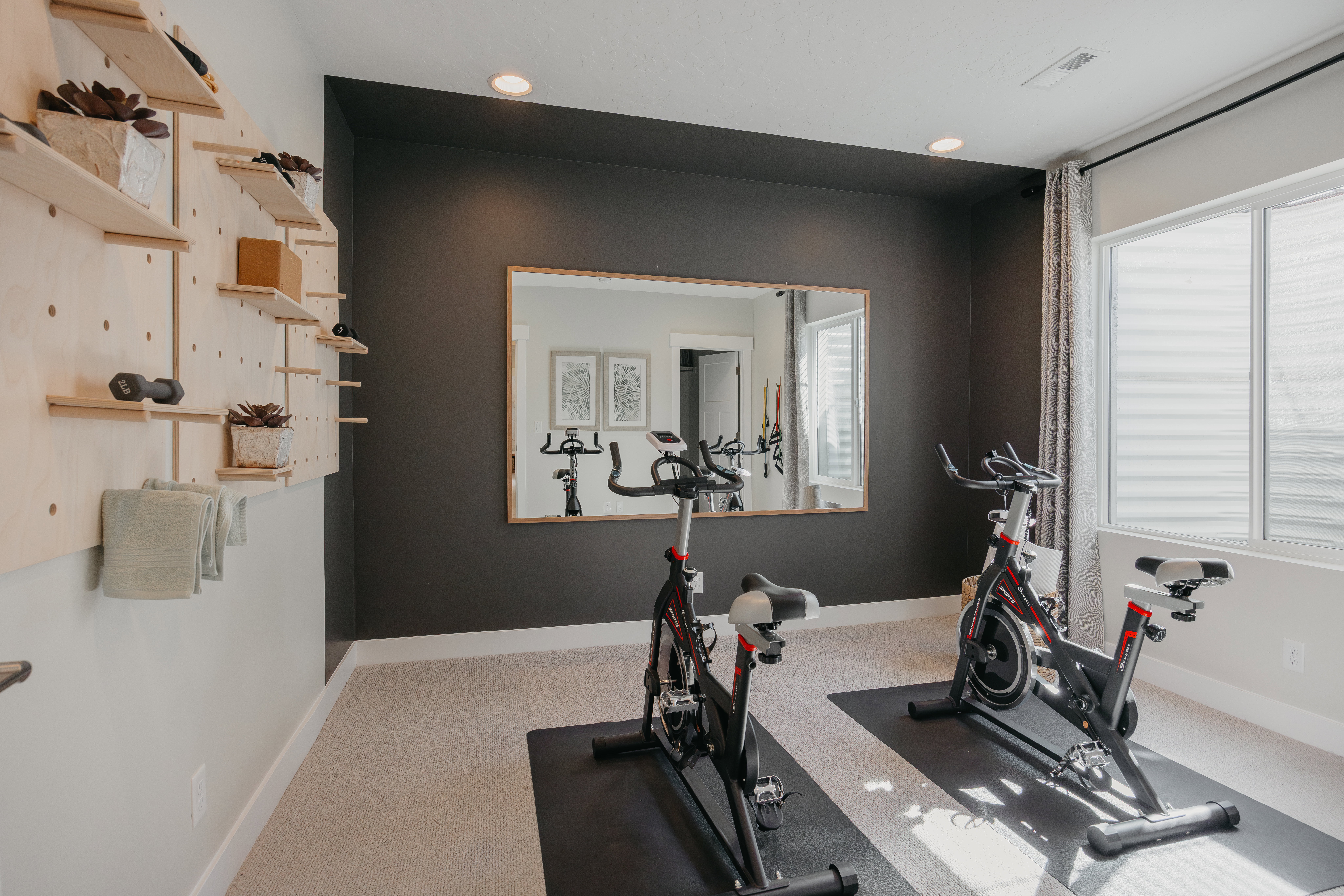 Dedicated room featuring recessed lighting, a large framed wall mirror, and a pegboard shelving system