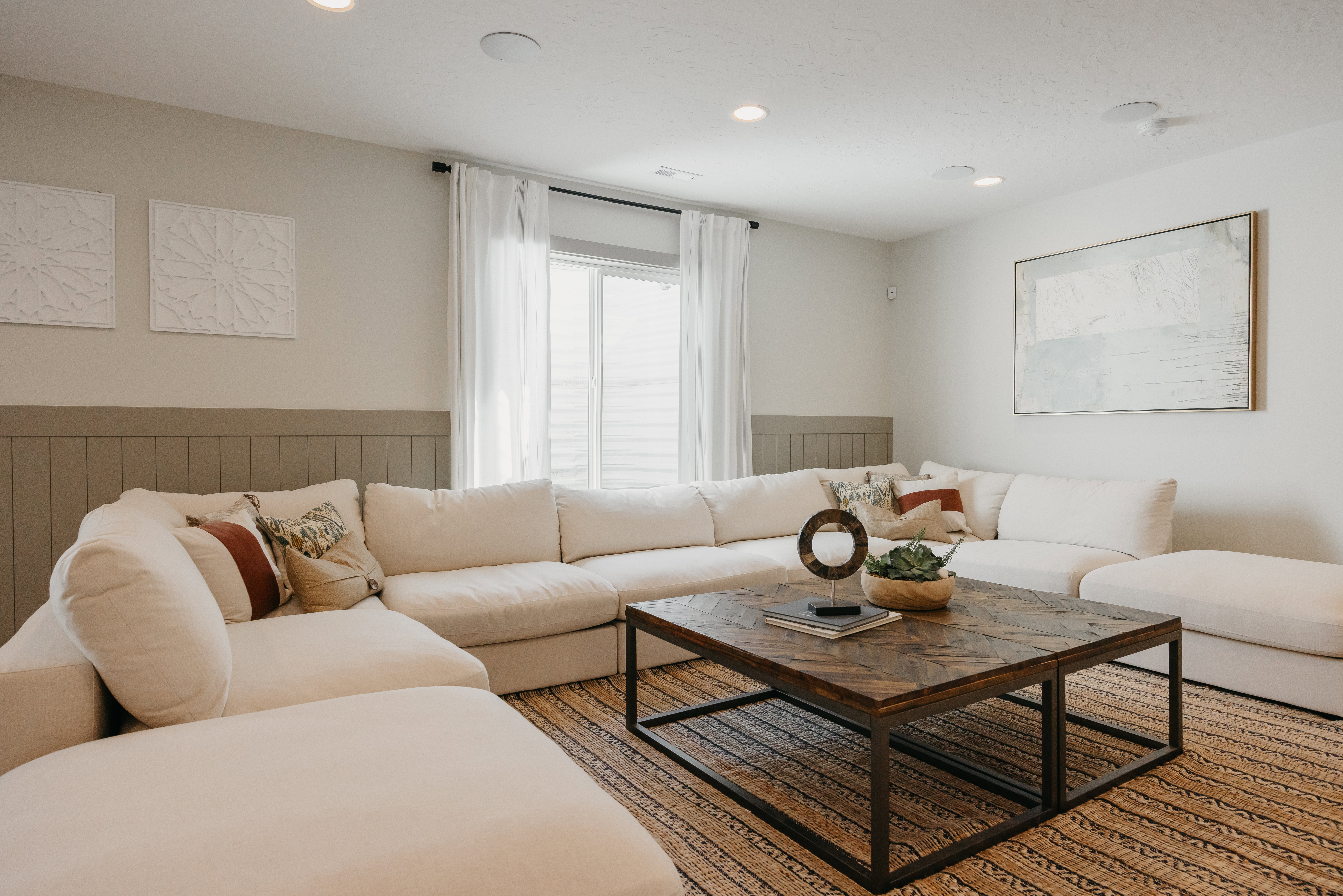 Living area featuring recessed lighting, a window with sheer curtains, board and batten wall detailing, and a patterned area rug