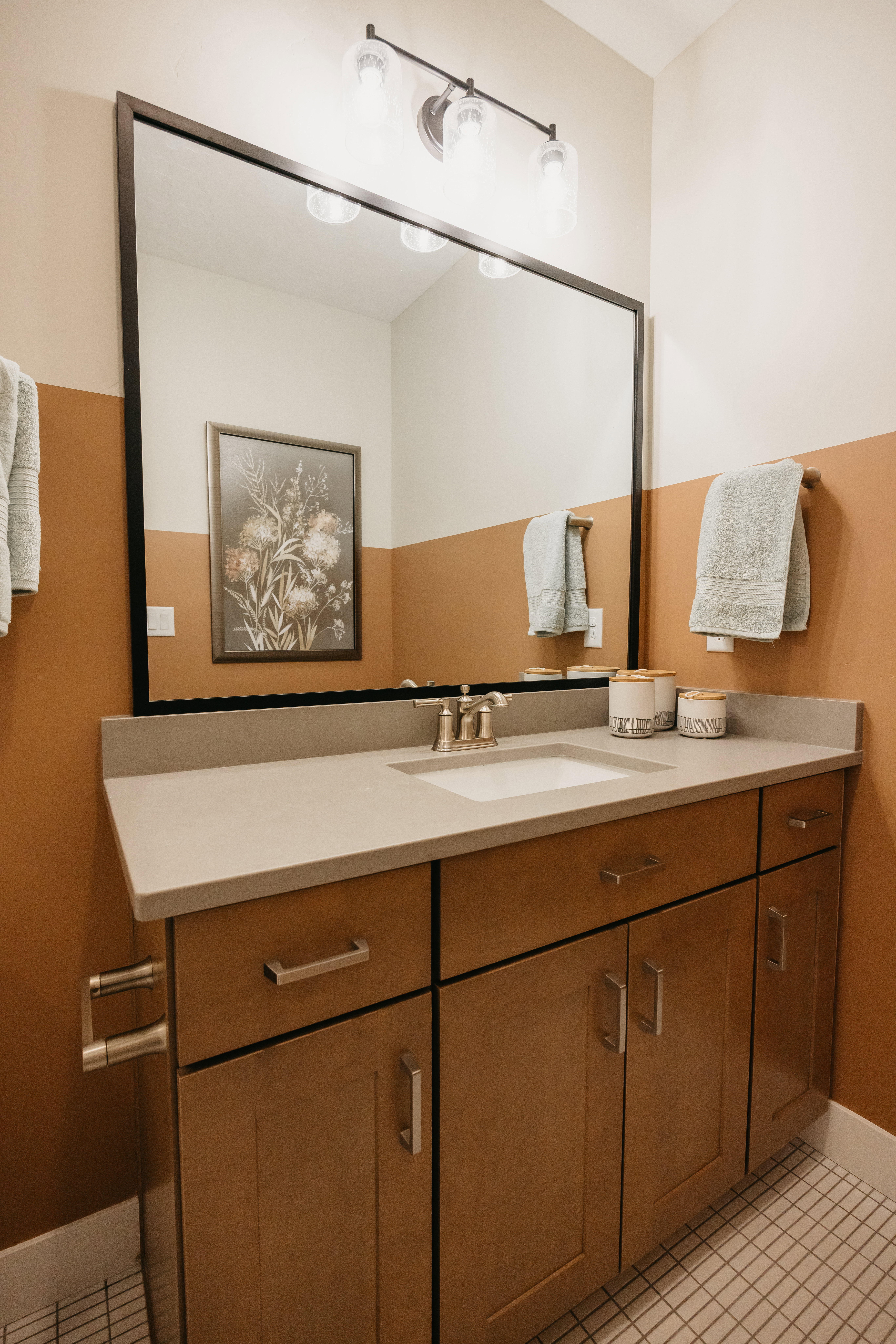 Bathroom vanity featuring wood-finish cabinetry, a light-toned countertop, and an integrated sink