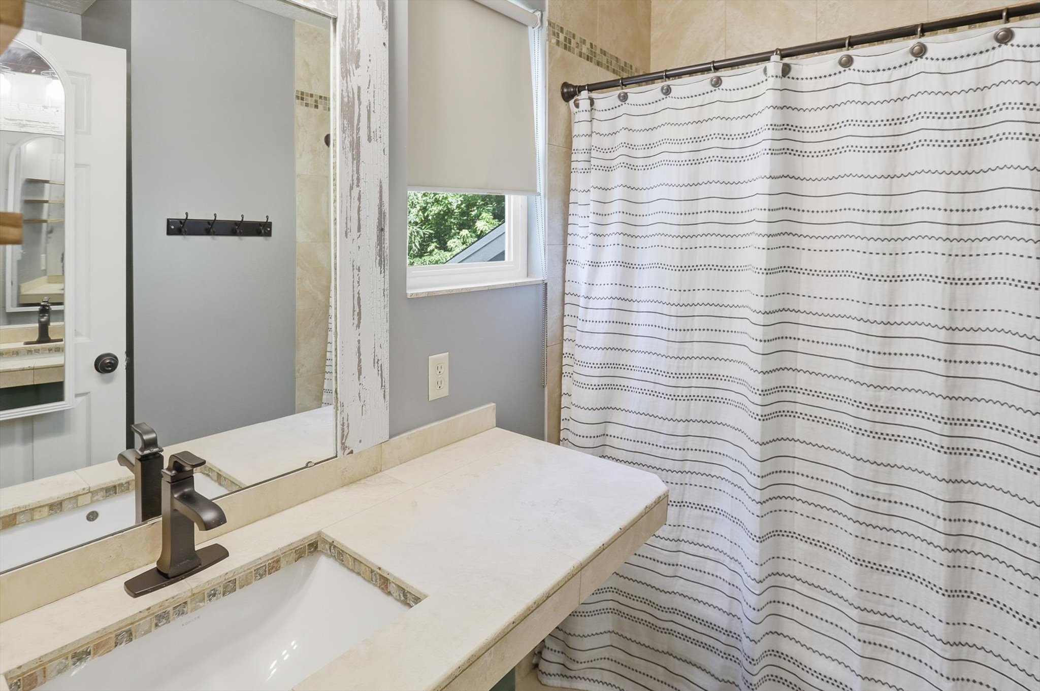 Bathroom vanity featuring a single basin sink, bronze-finish faucet, and coordinating countertop