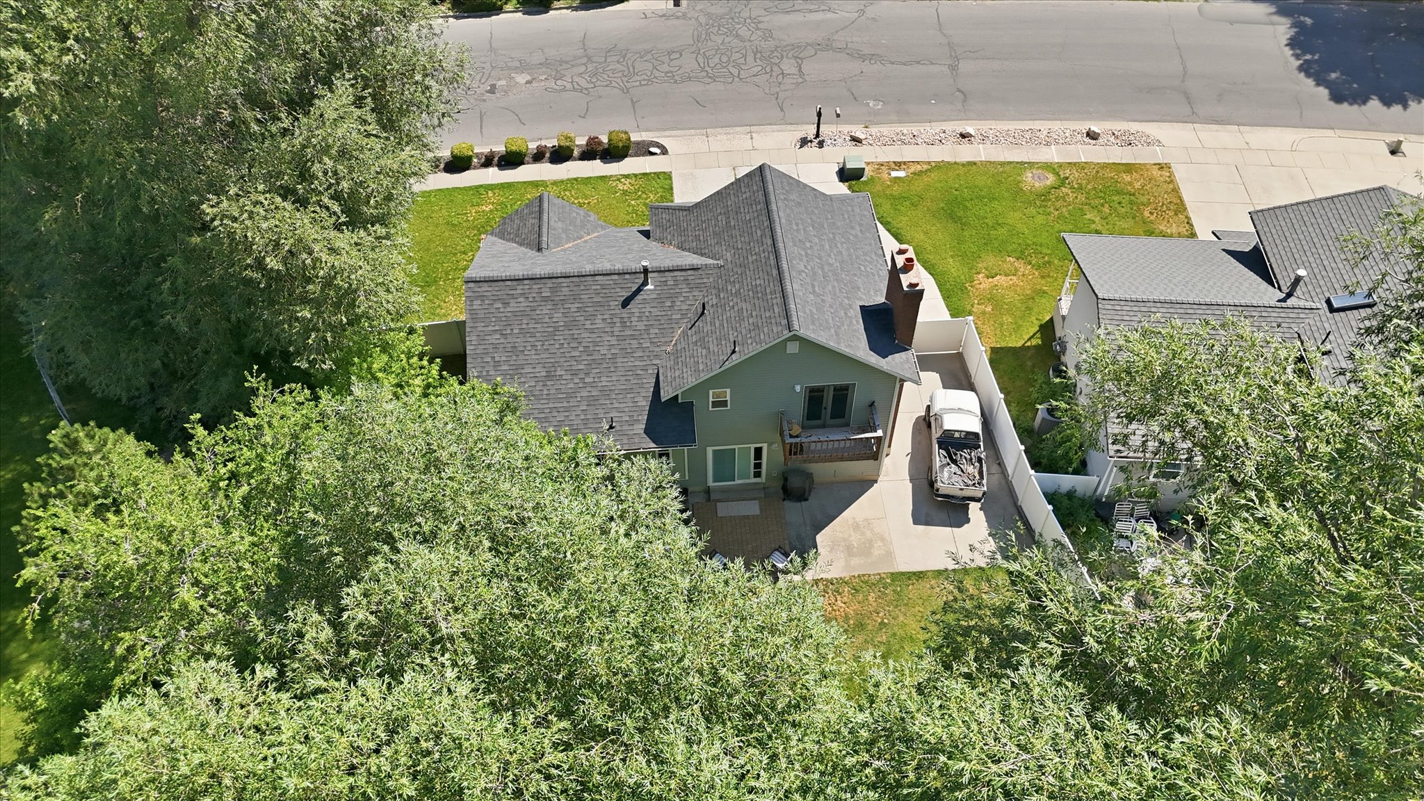 Two-story residence with a gray shingle roof, light green siding, and a rear balcony