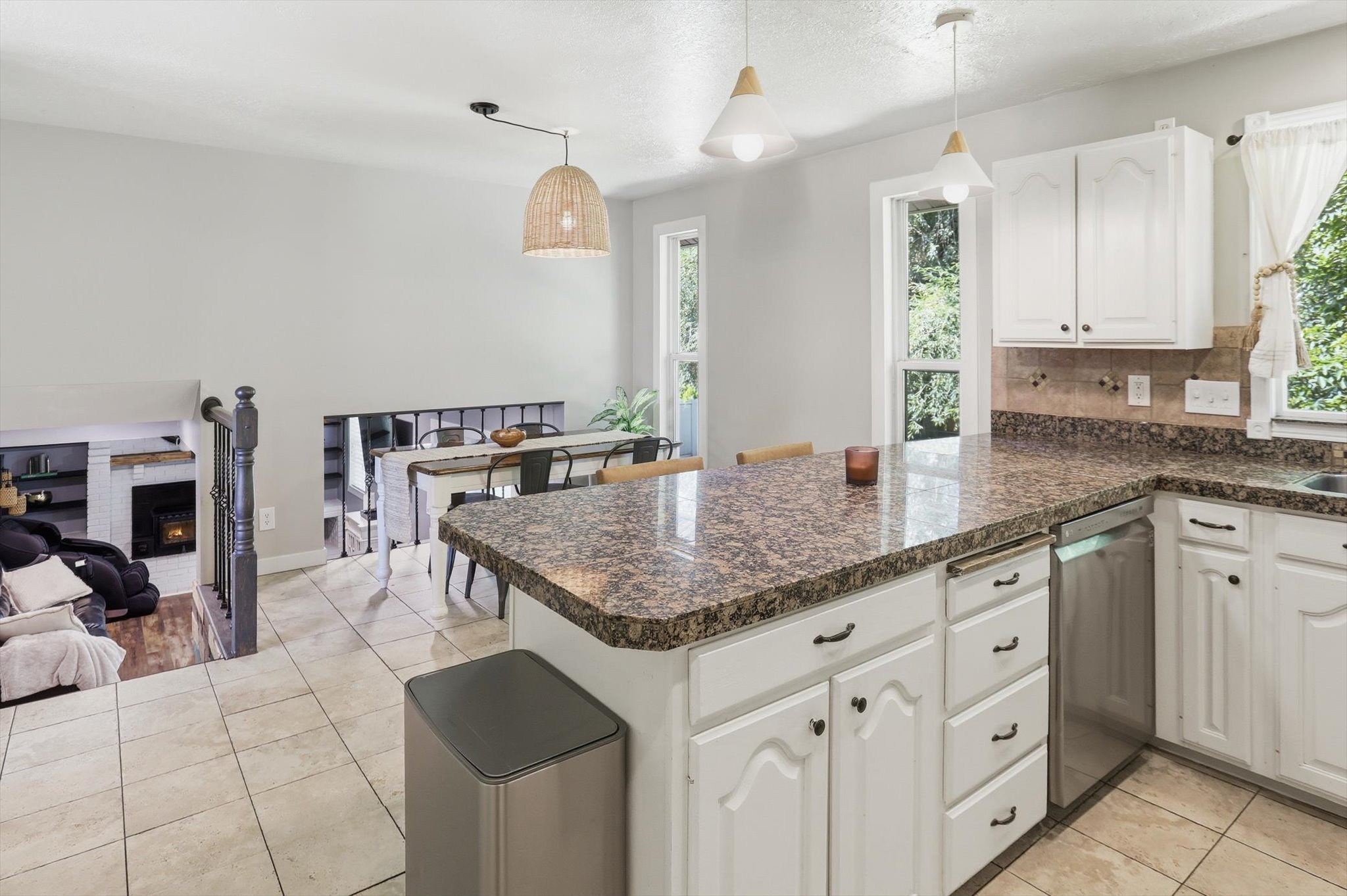 Kitchen with white cabinetry, granite countertops, and a stainless steel dishwasher