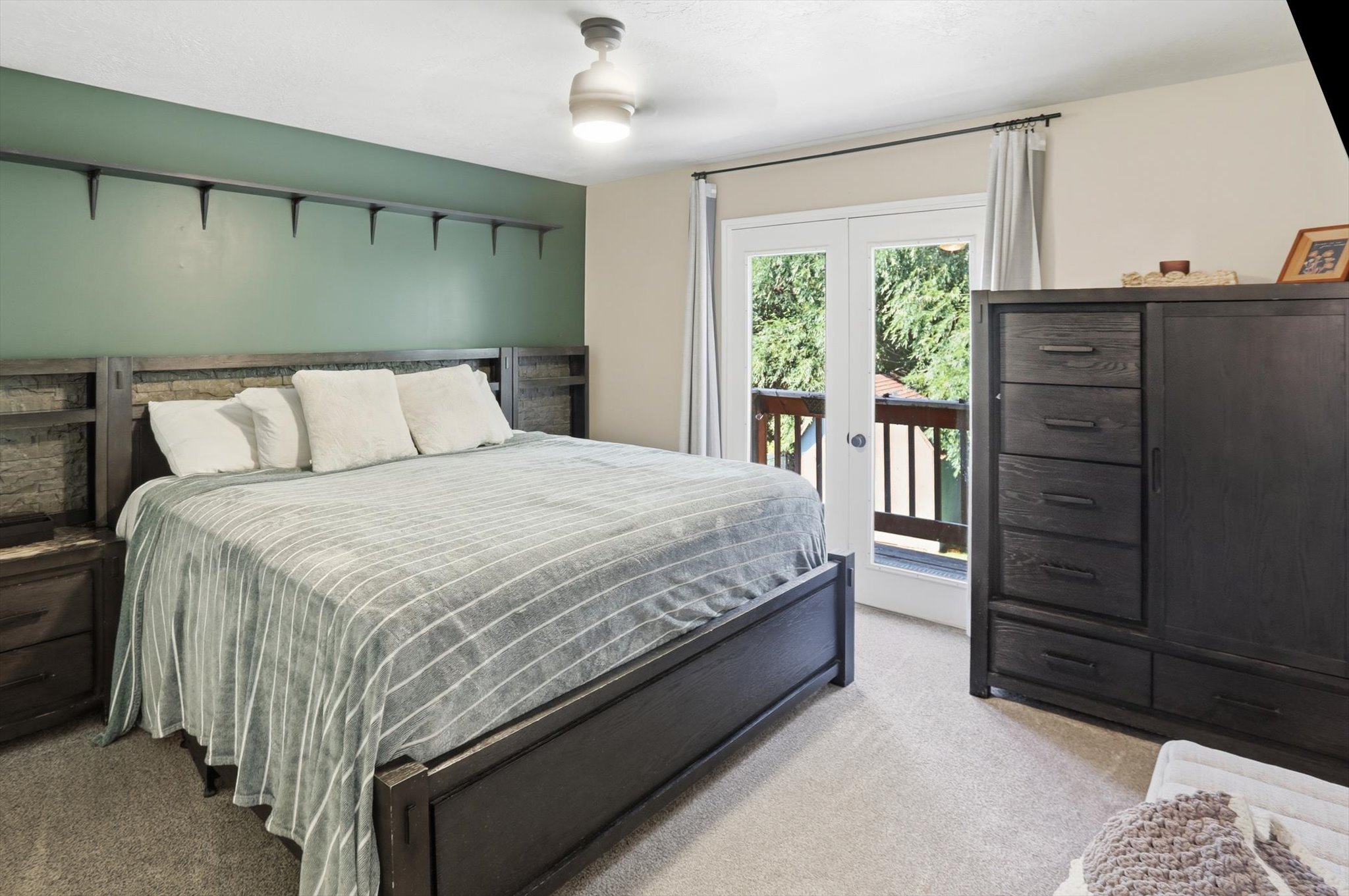 Bedroom featuring a private balcony with french doors, light-toned carpeting, and a built-in ceiling fan