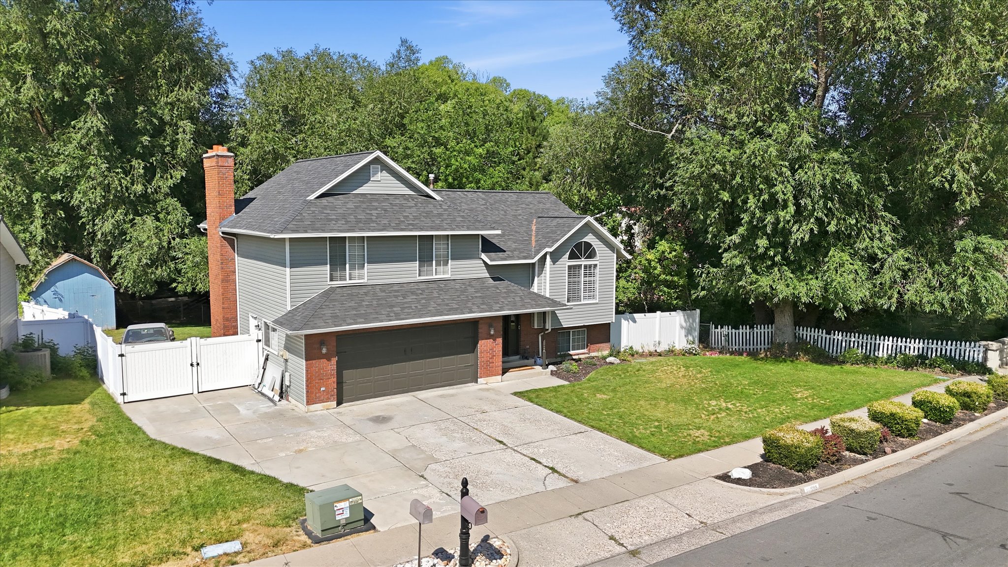 Two-story residence featuring grey siding and brick detailing