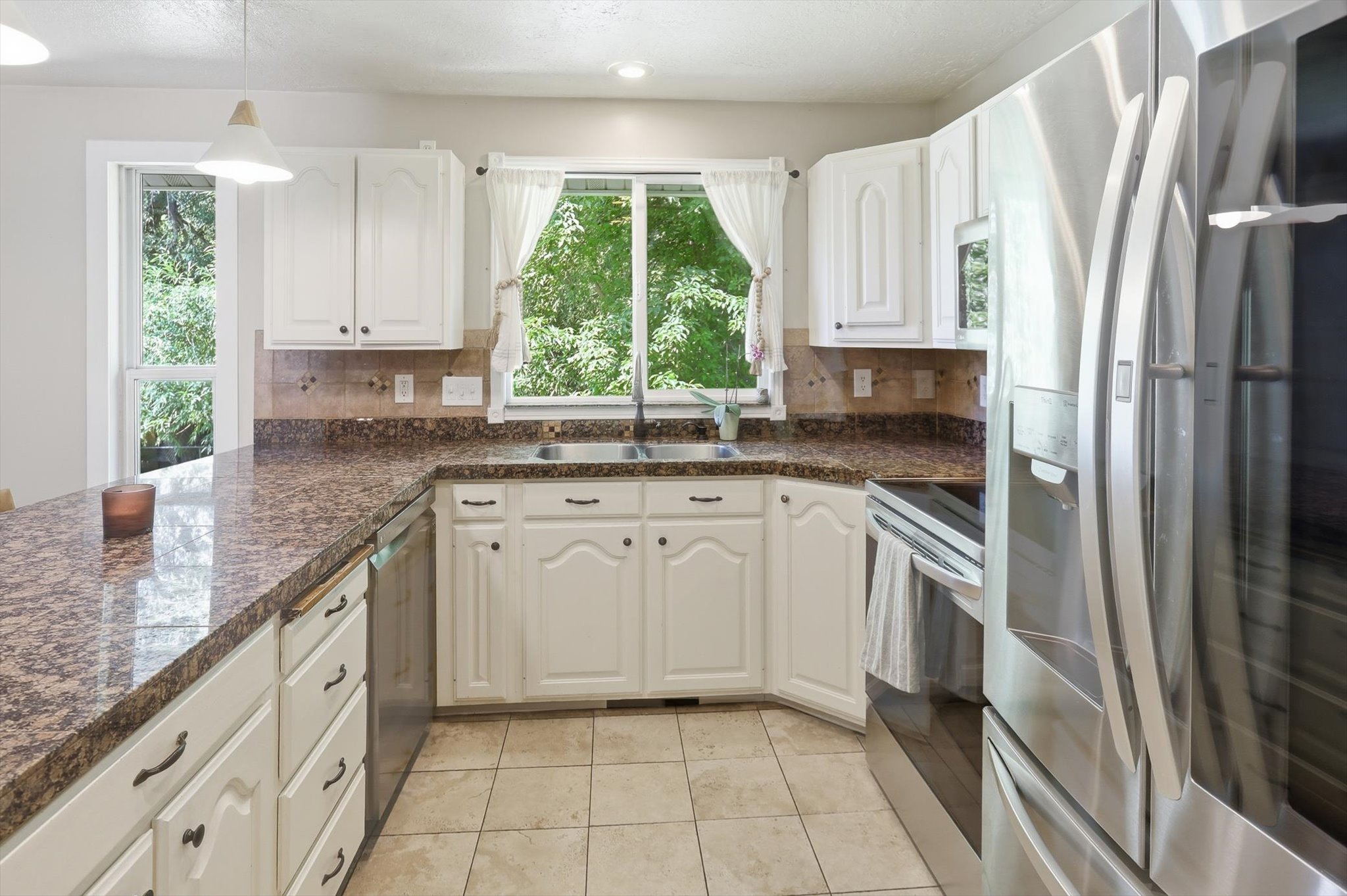 Kitchen featuring white cabinetry, stone-finish countertops, stainless steel appliances, tile flooring, and a double basin sink