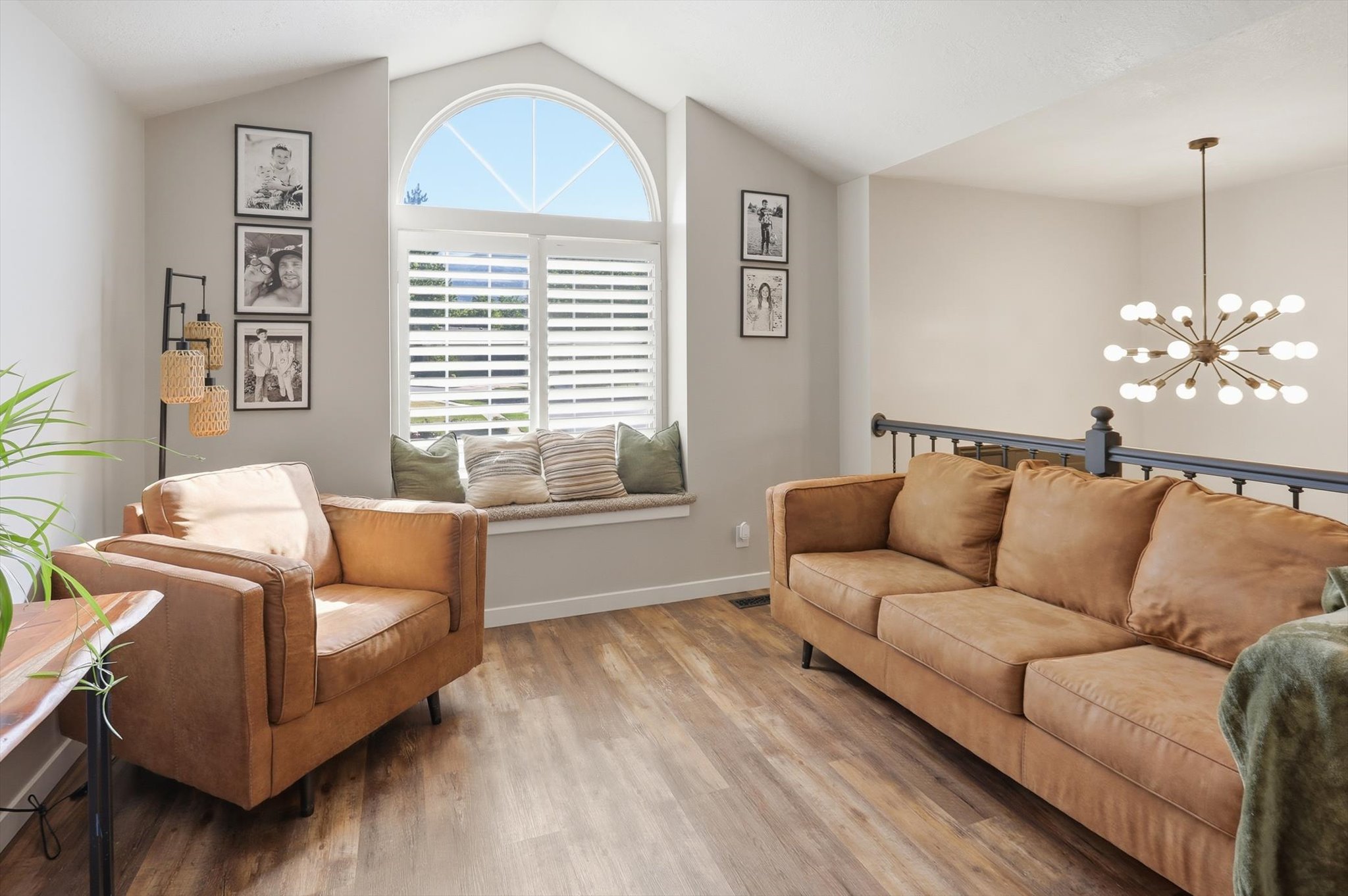 Vaulted ceiling living space featuring wood-finish flooring
