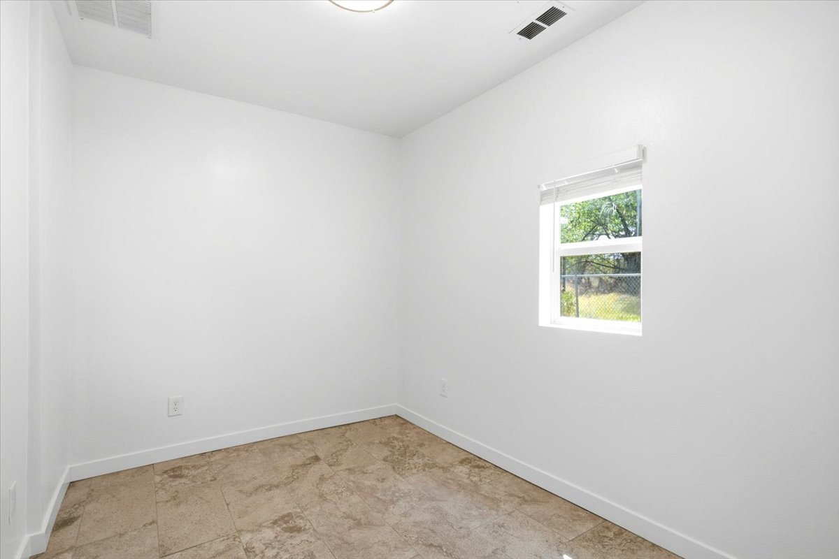 White-painted interior room featuring a single window with blinds