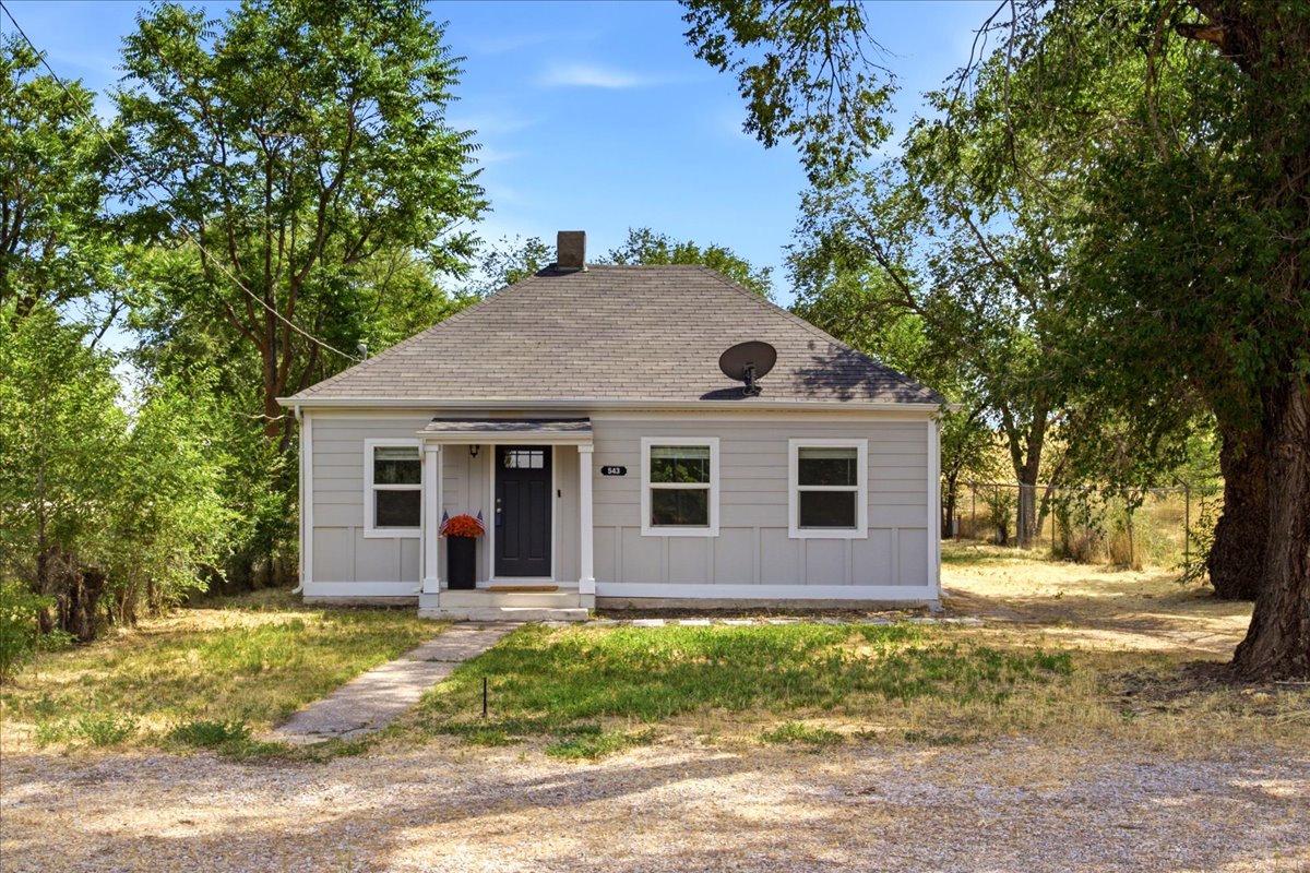 Light gray siding exterior with white trim and a dark gray asphalt shingle roof