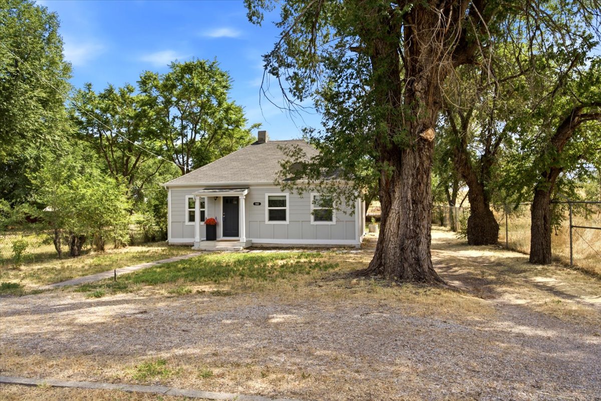 Single-story residence featuring light gray siding, a dark gray roof, and white window trim
