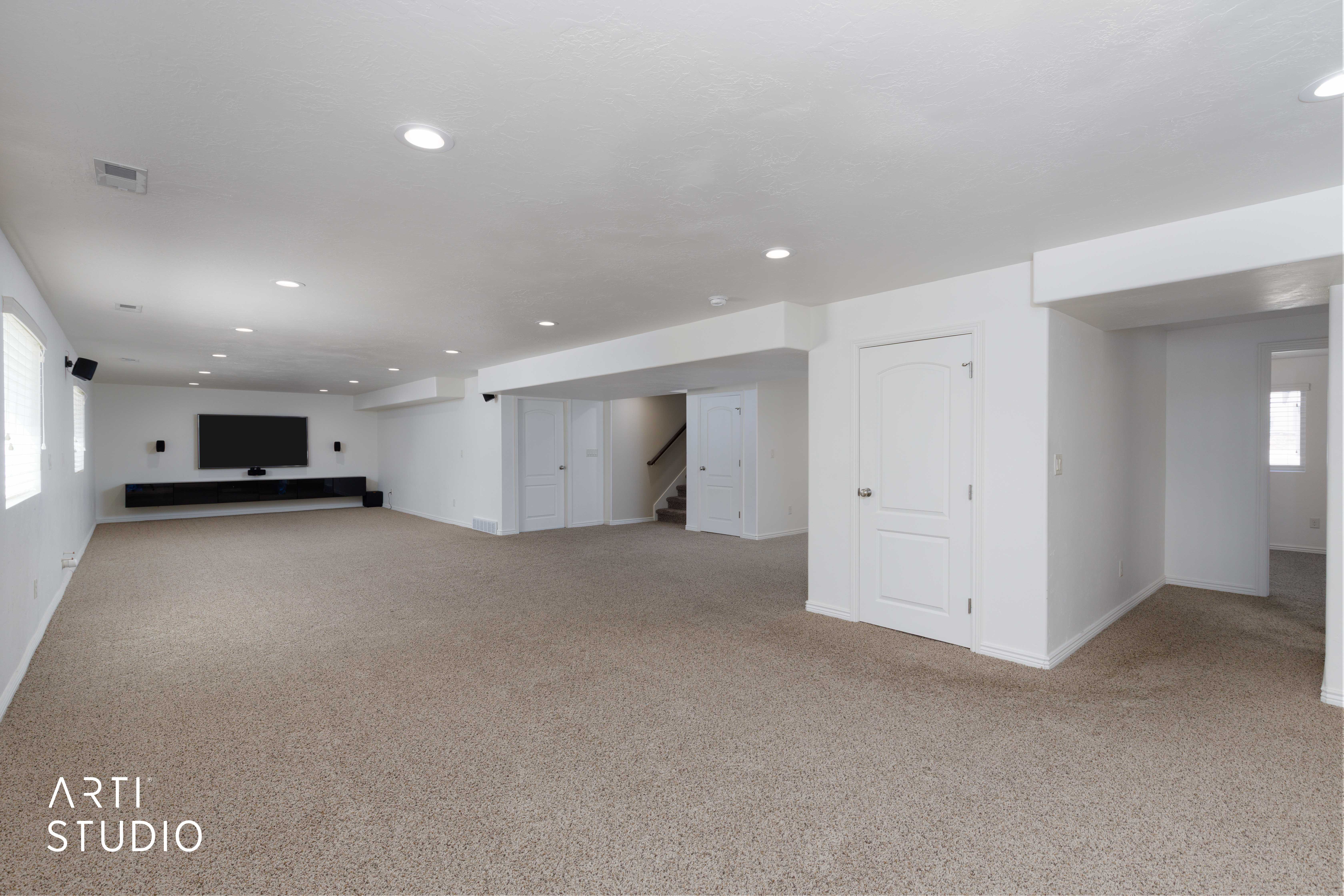 Spacious carpeted room featuring recessed lighting, a built-in media console, multiple windows with blinds, and white interior doors