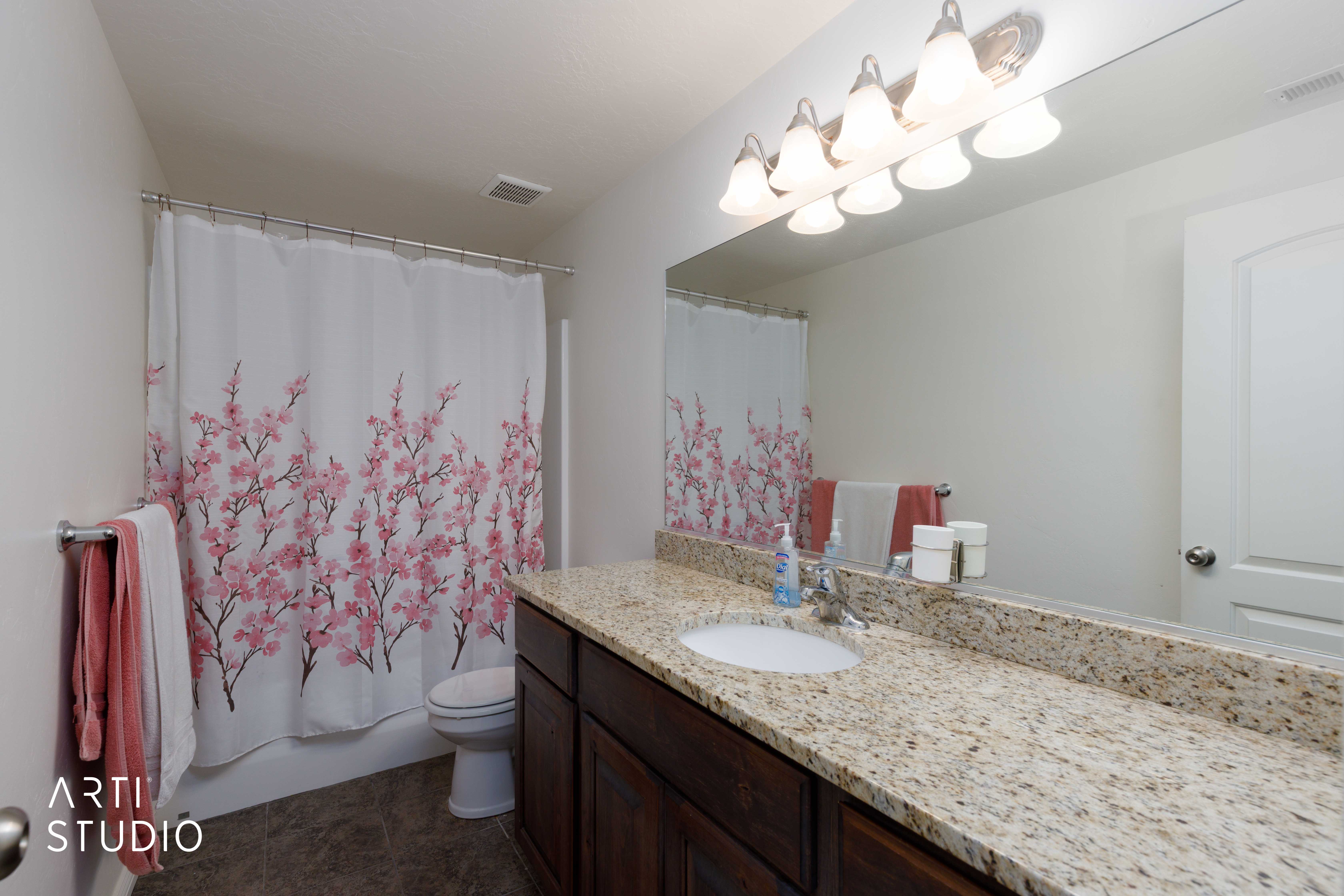 Bathroom featuring a vanity with a light-colored speckled countertop, an undermount sink, and dark wood cabinetry