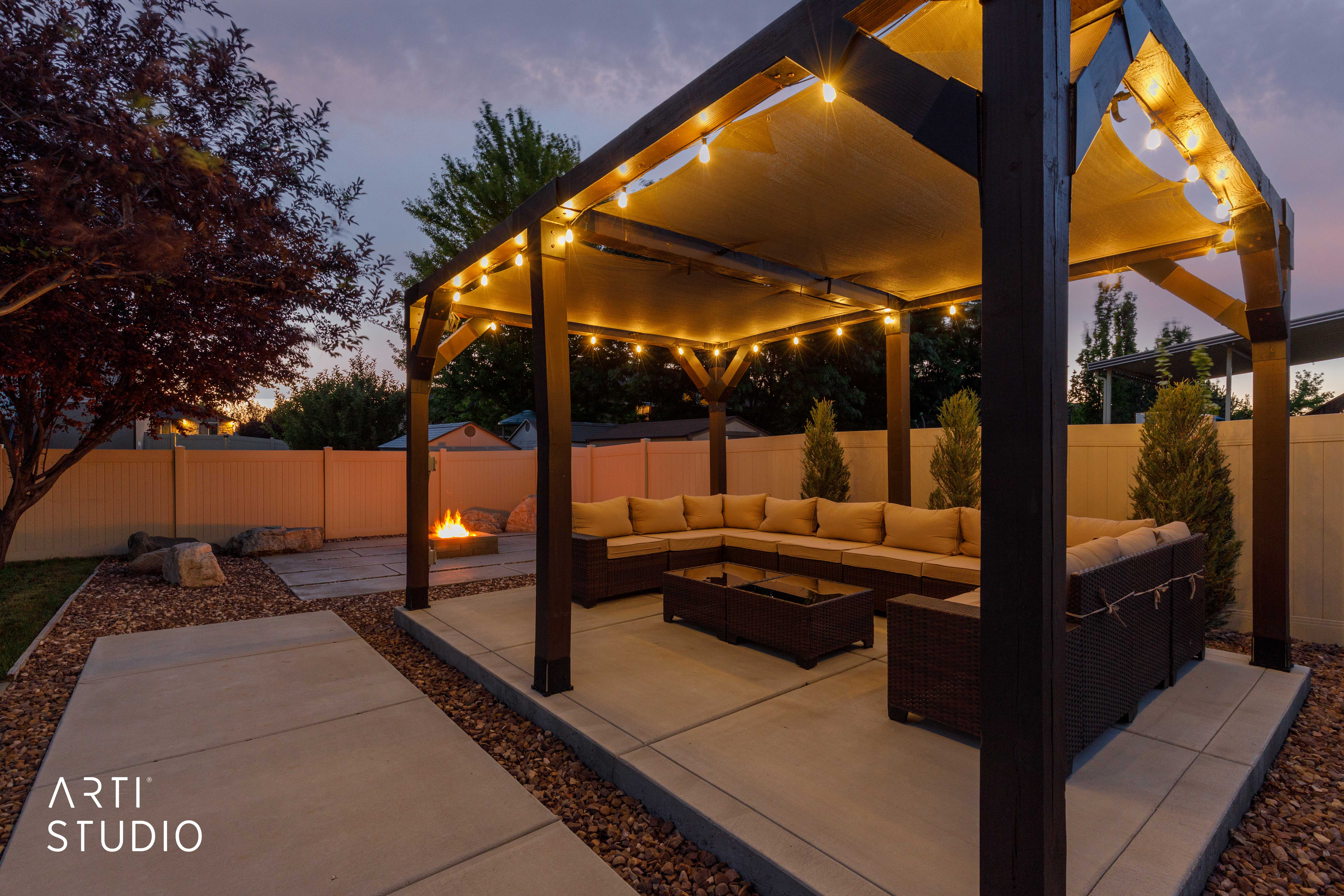 Outdoor living area featuring a pergola with integrated lighting, a concrete patio, and a dedicated fire pit