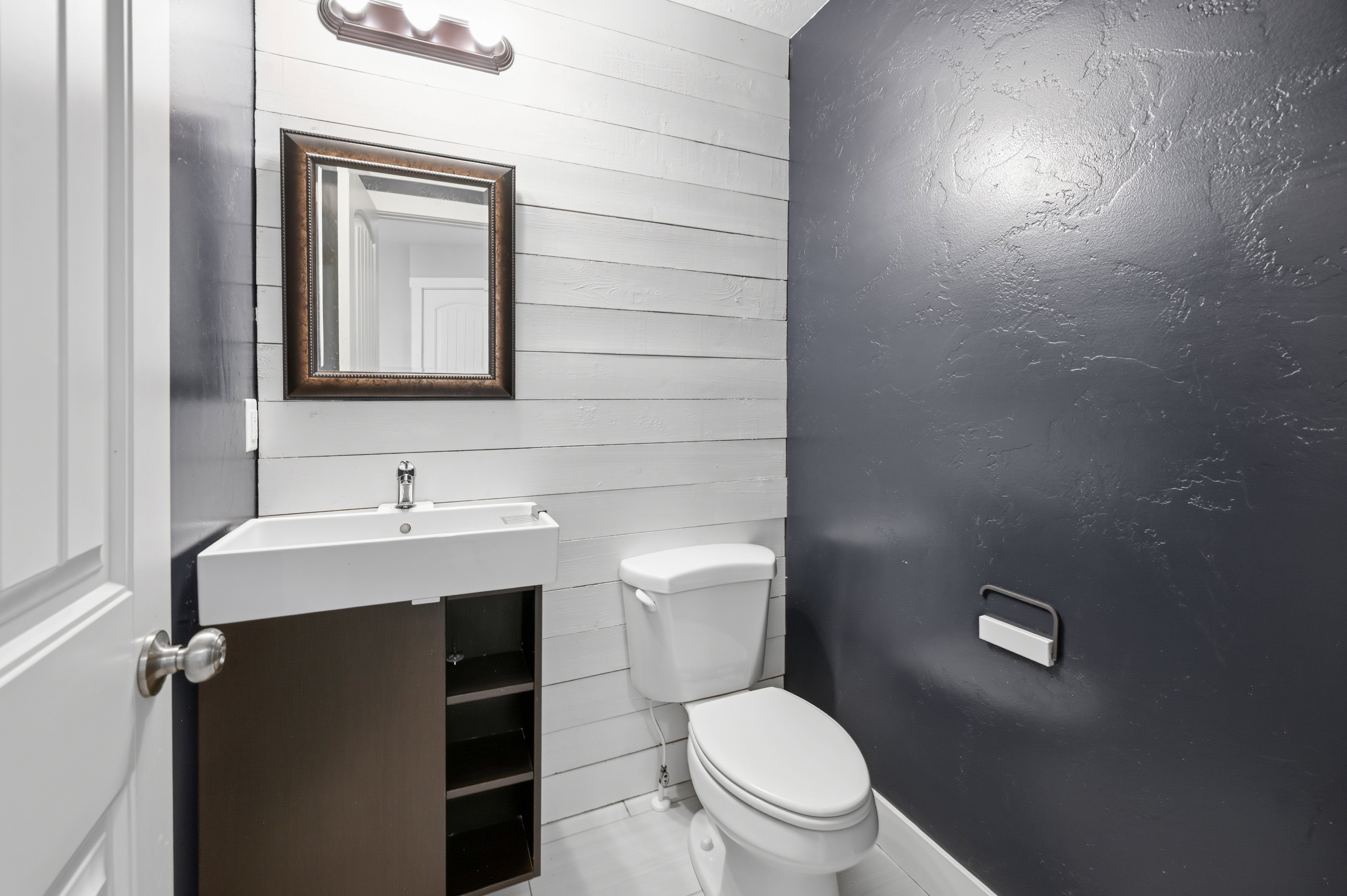 Bathroom featuring a modern floating vanity with an integrated sink, a dark wood-finish cabinet, and a framed mirror
