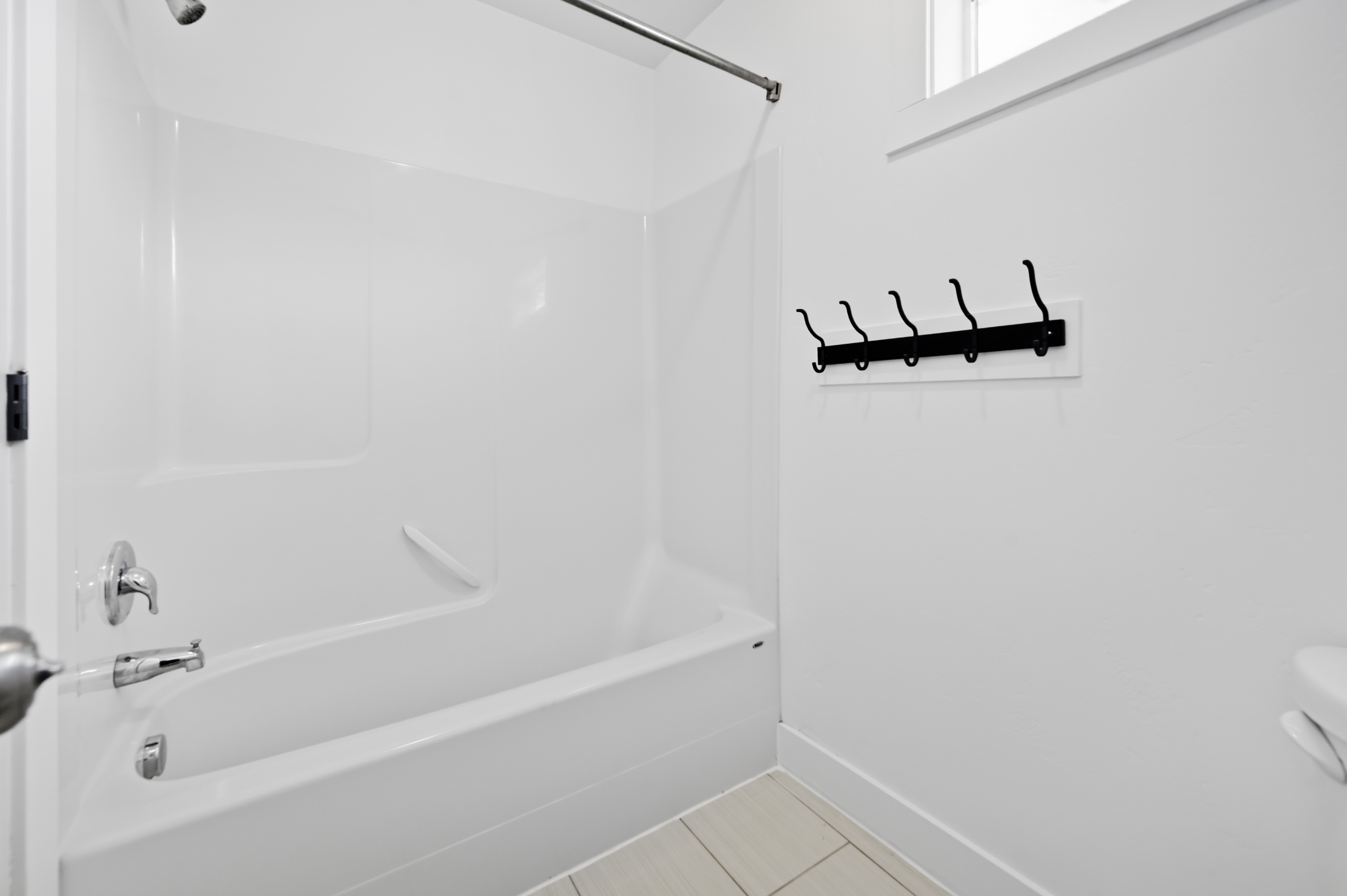 White tub and shower combination with chrome fixtures