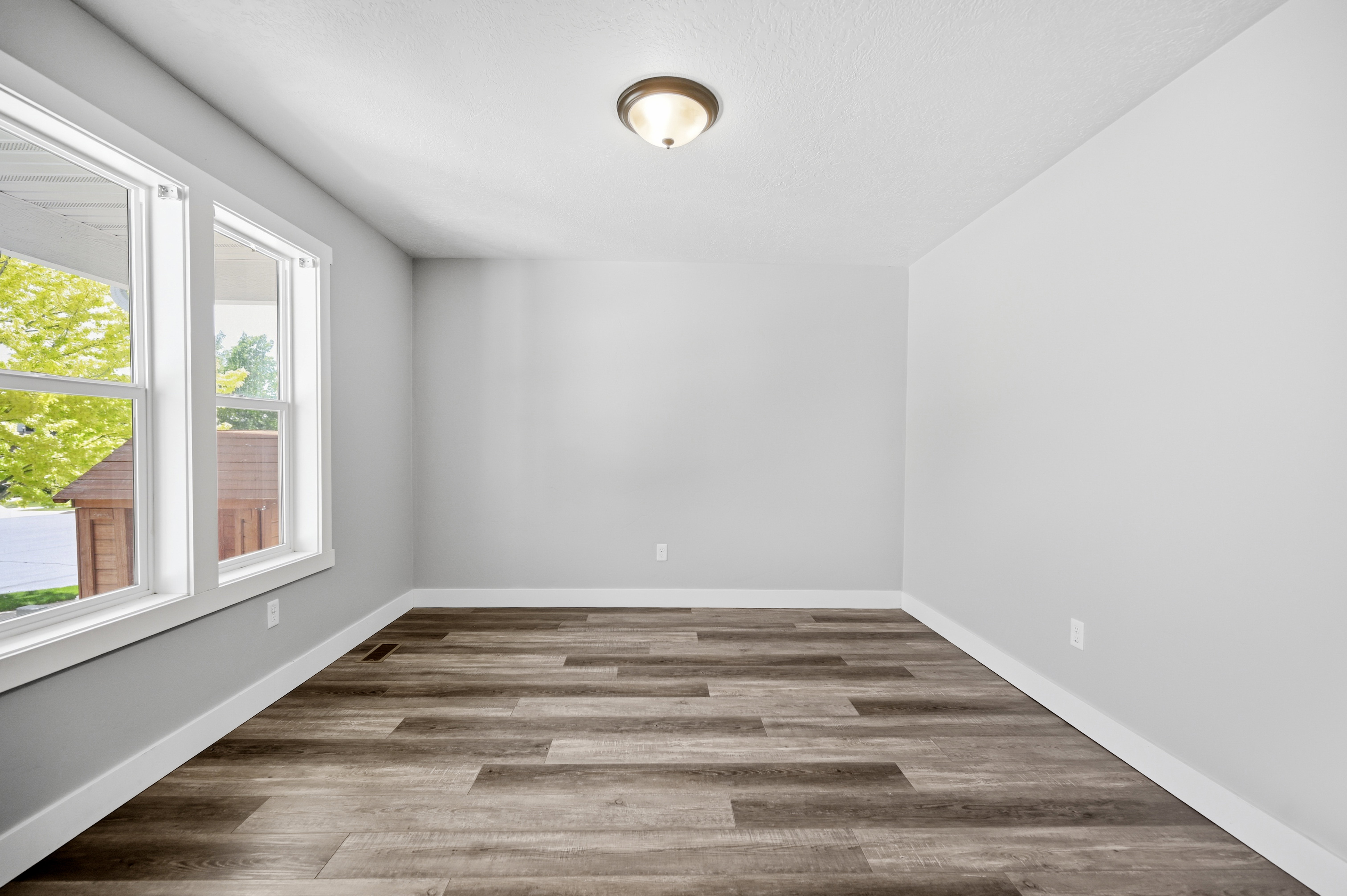 Room featuring wood-finish flooring, light gray walls, white trim, and a semi-flush mount ceiling light fixture