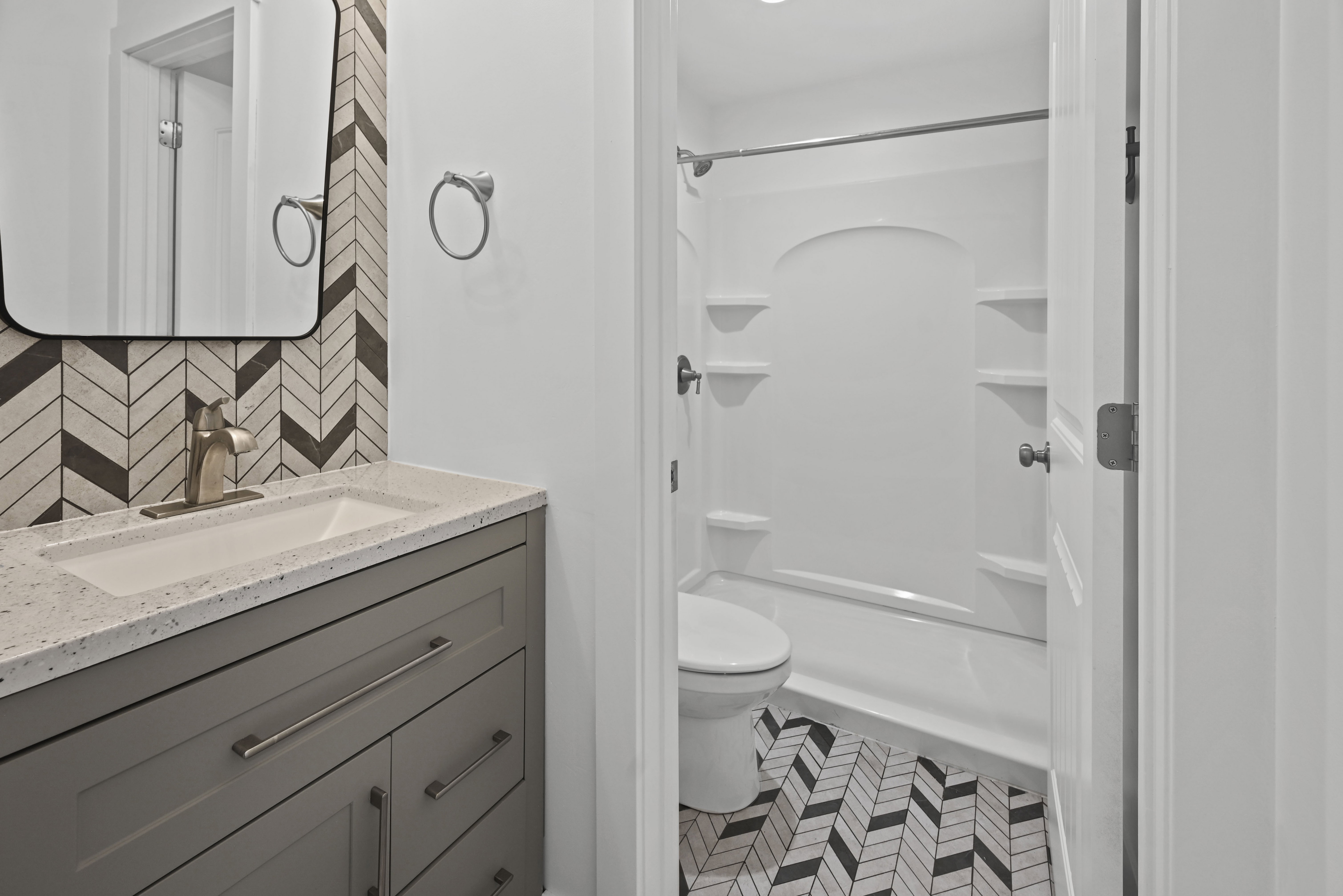 Bathroom featuring a vanity with a light-toned countertop, an integrated sink, and gray cabinetry with brushed nickel hardware