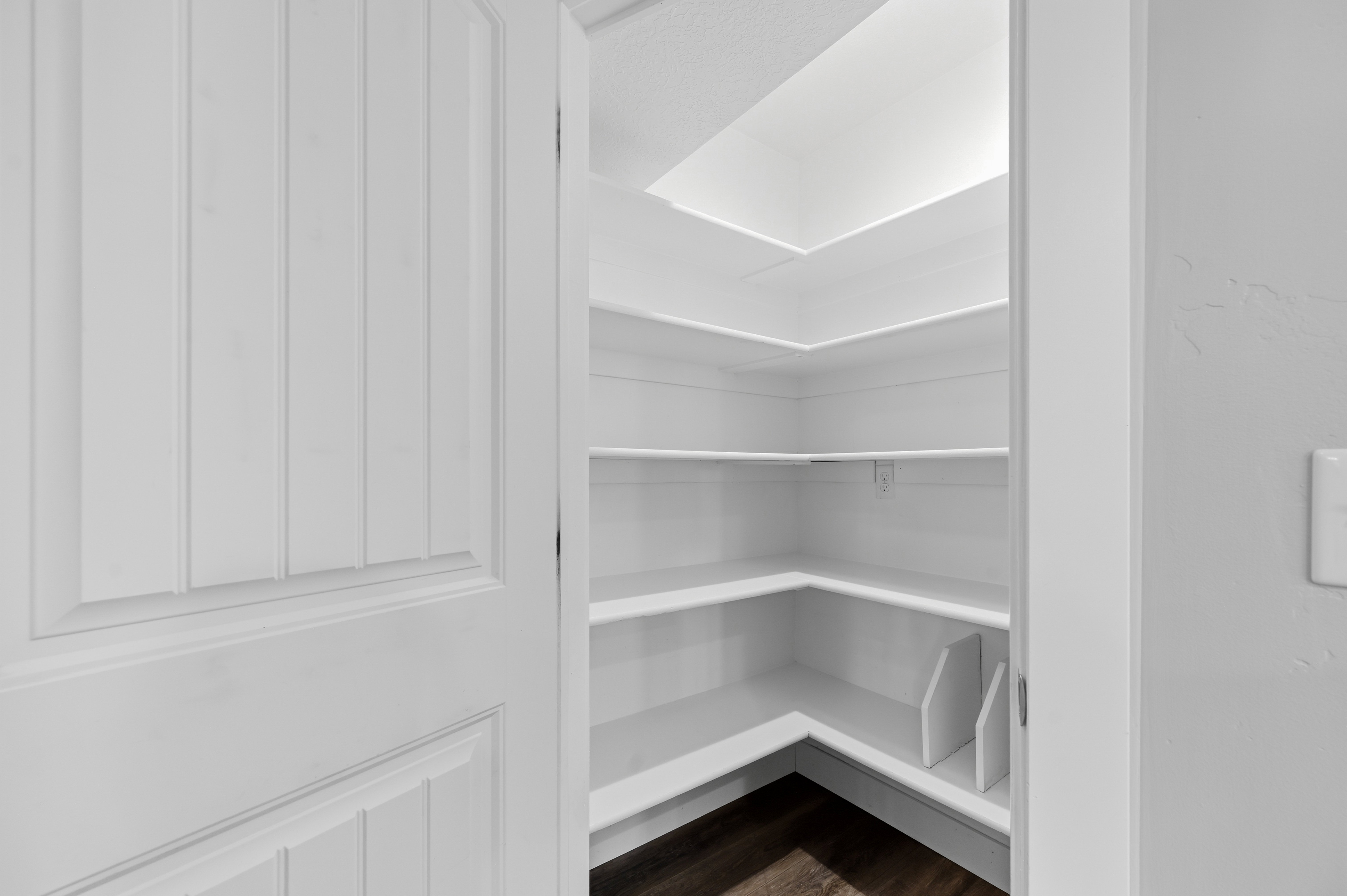 Pantry with multi-level shelving, recessed lighting, and wood-finish flooring