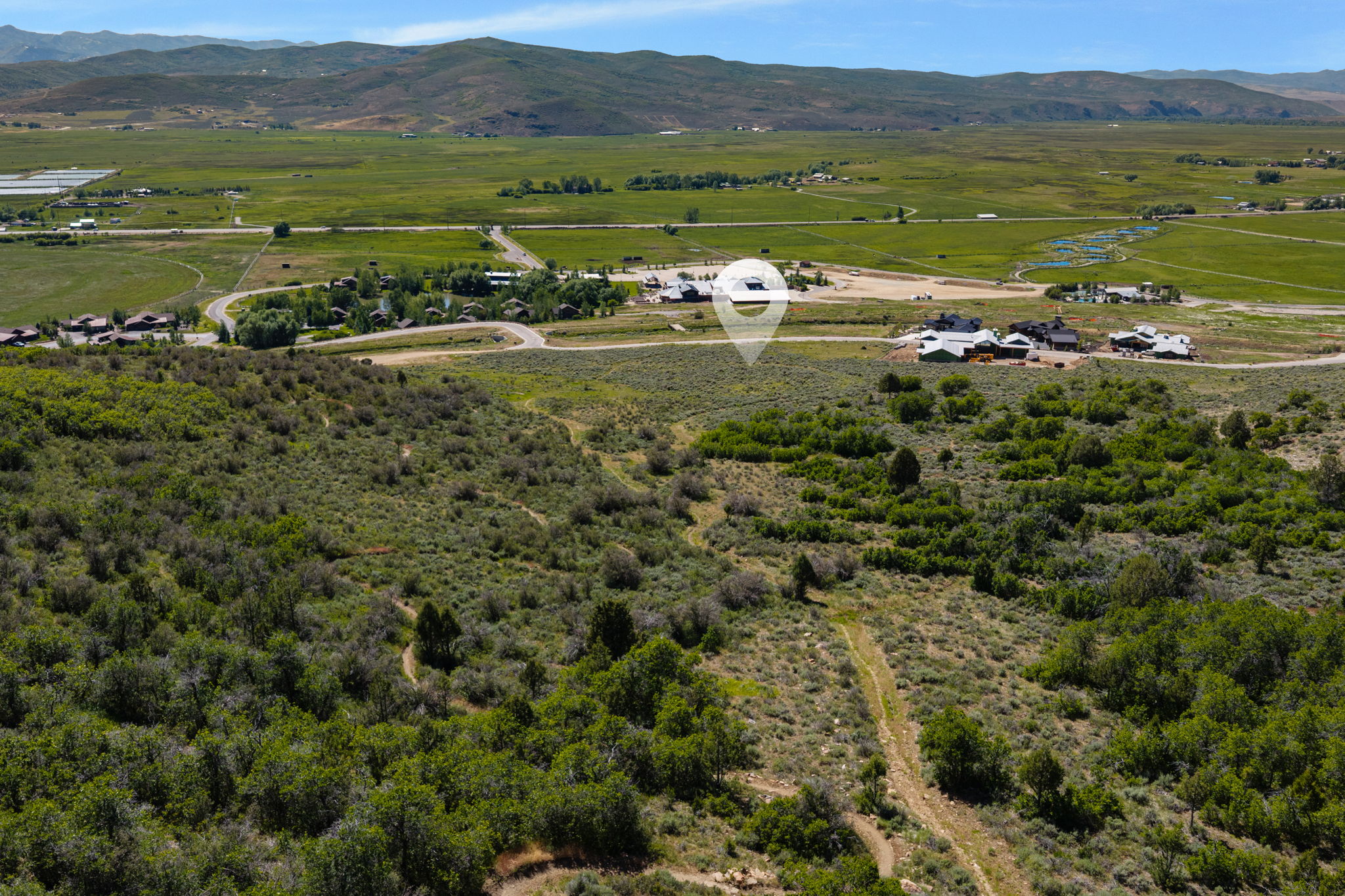 Expansive undeveloped land featuring natural foliage and a dirt track