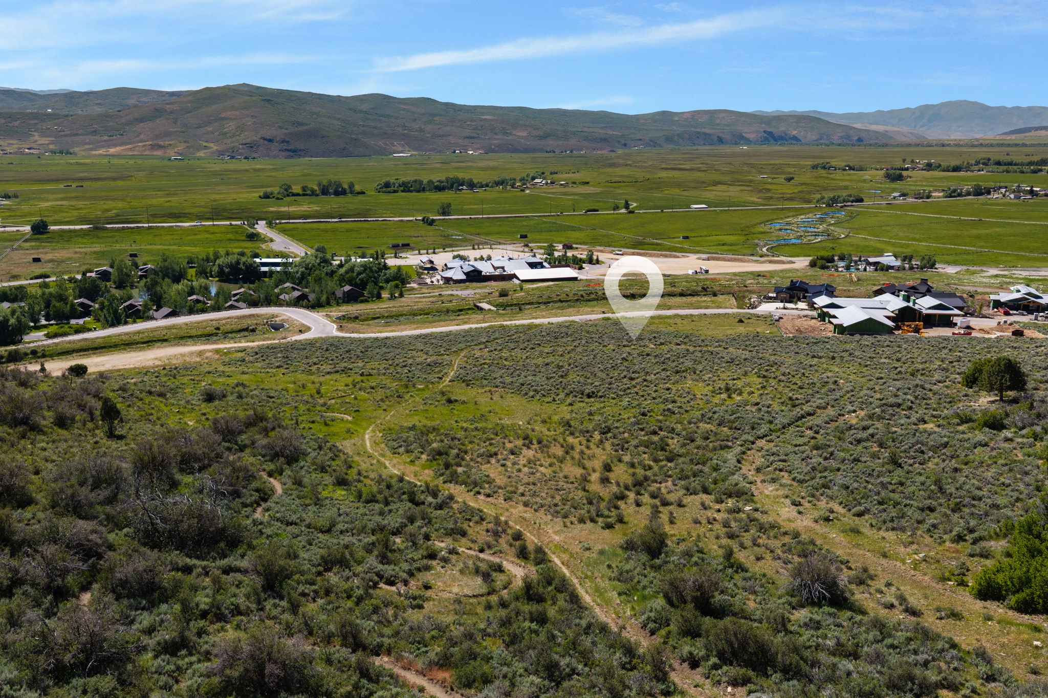 Expansive land parcel featuring natural vegetation and distant mountain ranges