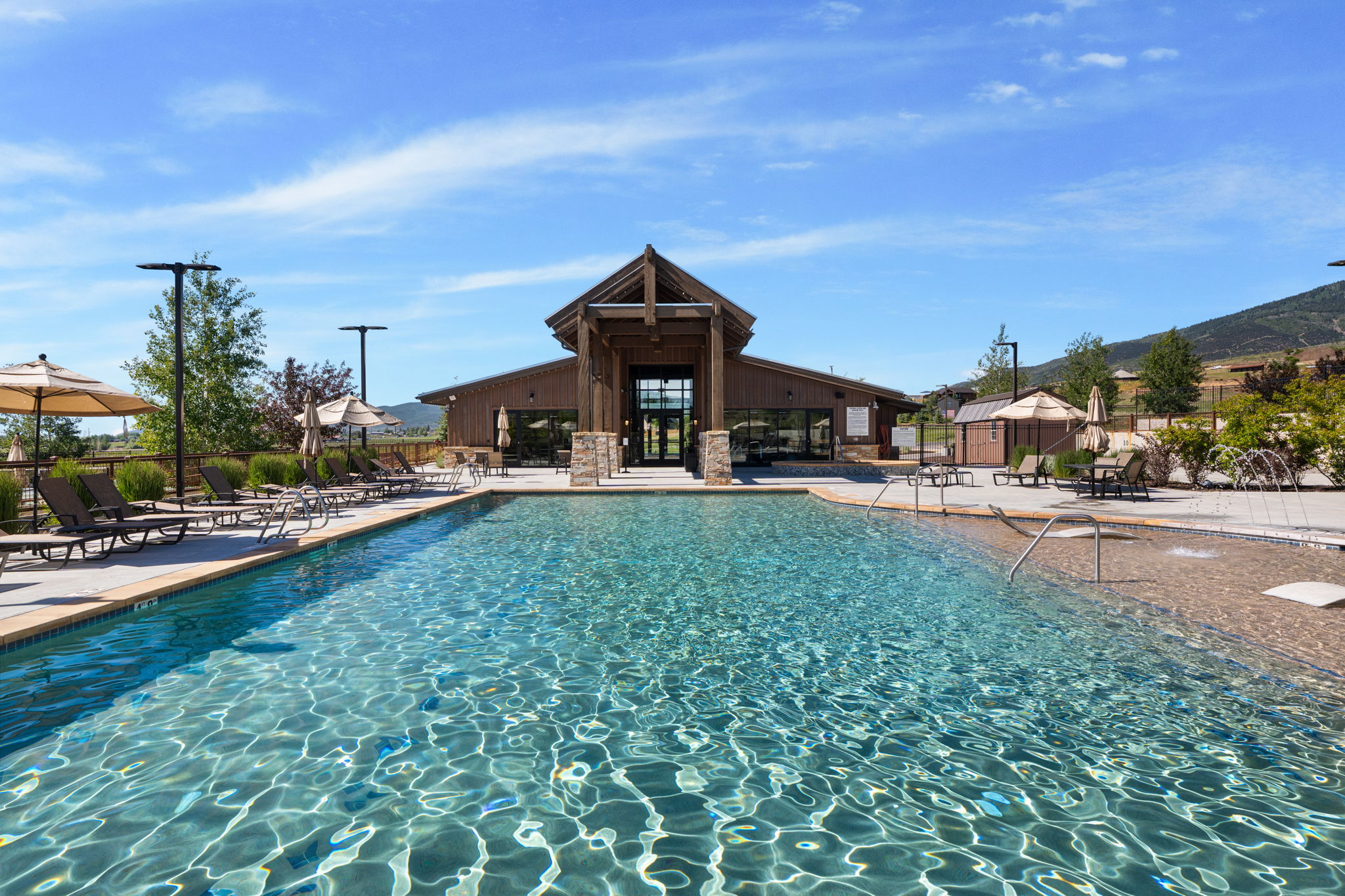 Expansive outdoor swimming pool with integrated shallow entry and surrounding lounge areas