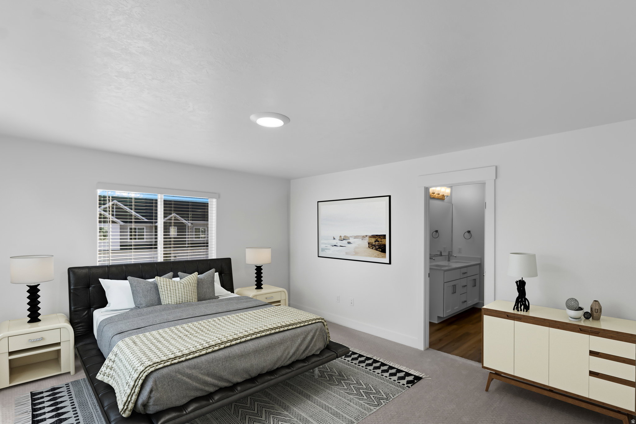 Carpeted bedroom featuring a single window with horizontal blinds, overhead flush-mount lighting, and a doorway revealing a bathroom with a dual vanity and wood-finish flooring
